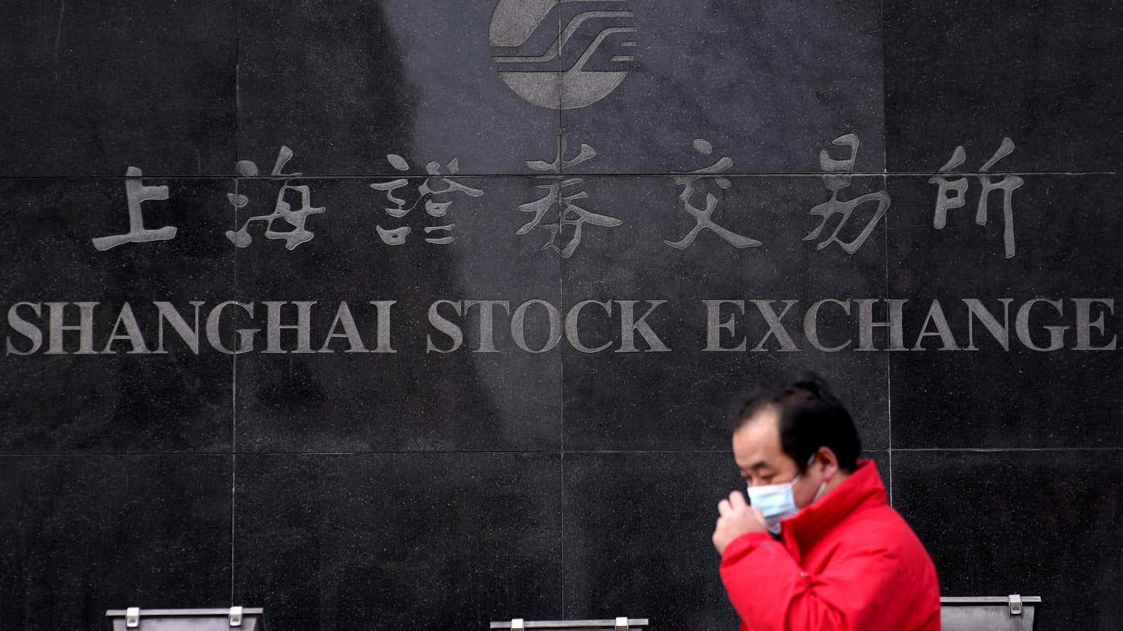 A man walks by the Shanghai Stock Exchange building.