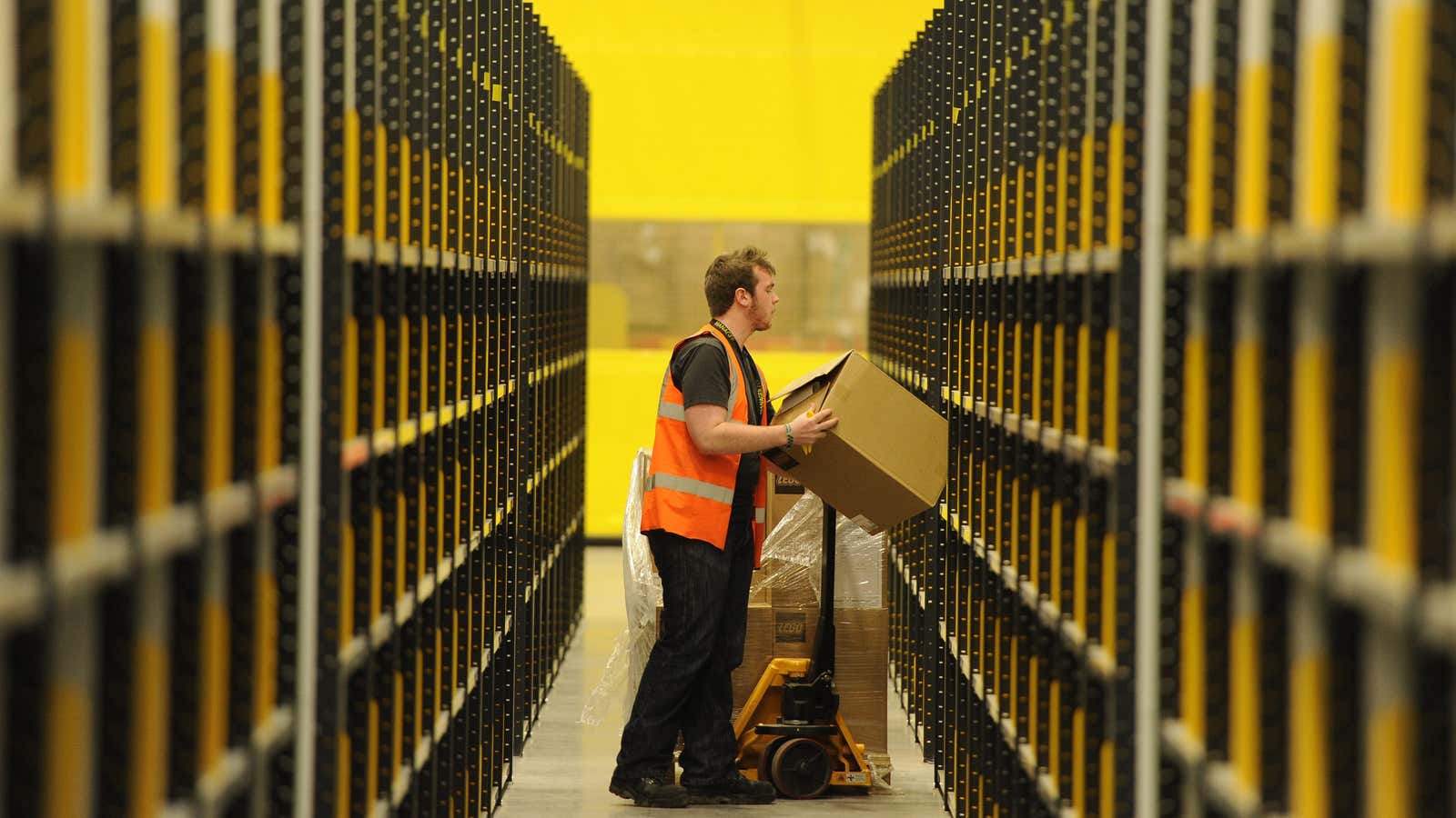 A worker lifts a box at Amazon’s new fulfilment centre after it was opened by Scotland’s First Minister Alex Salmond in Dunfermline, Scotland, November 15,…