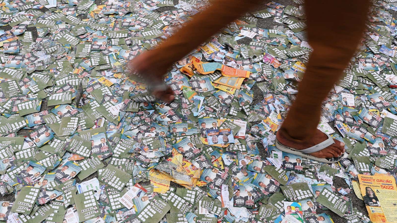 A person walks over election flyers in São Paulo.