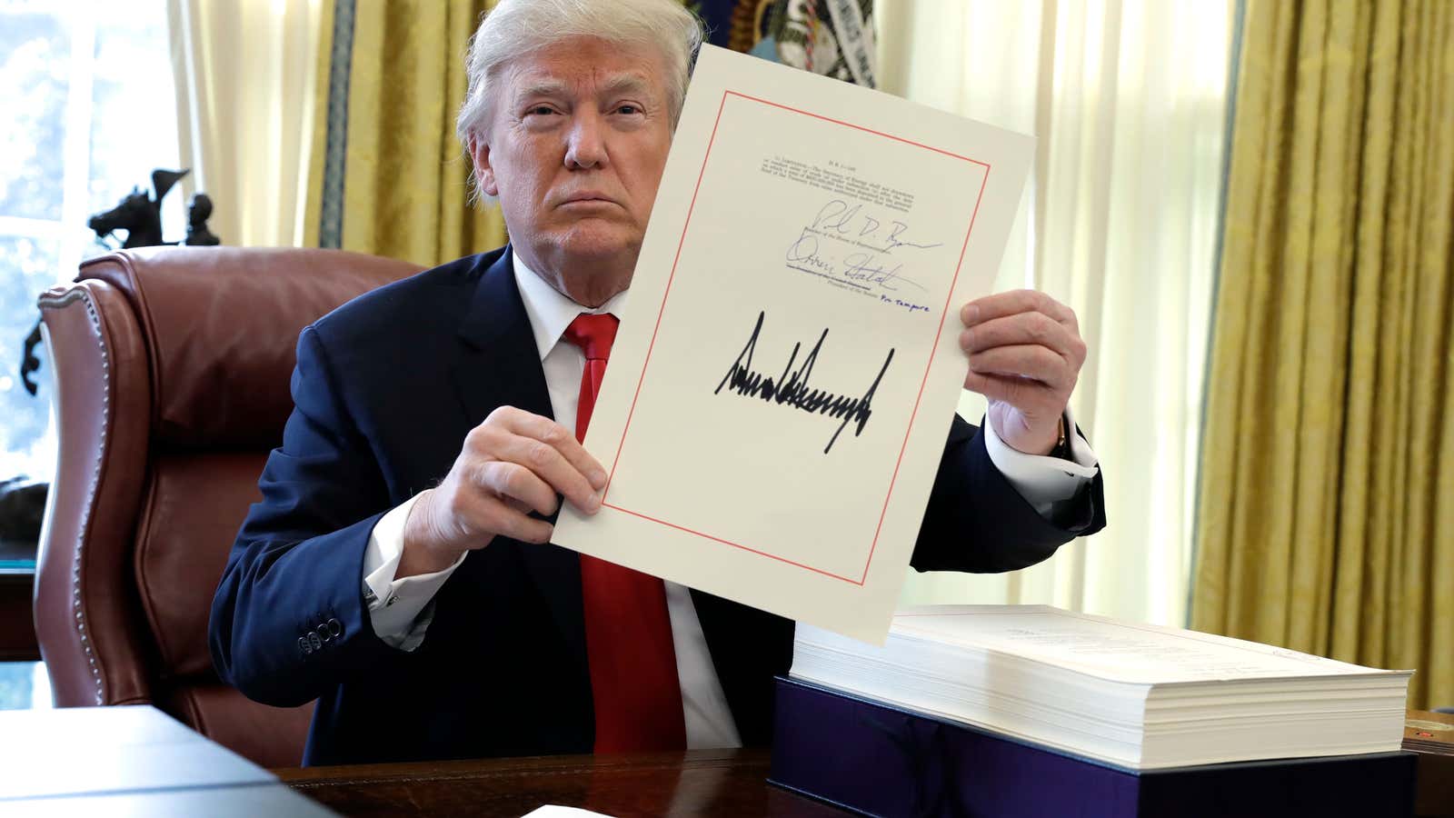 President Trump brandishes his massive tax cut in 2017.