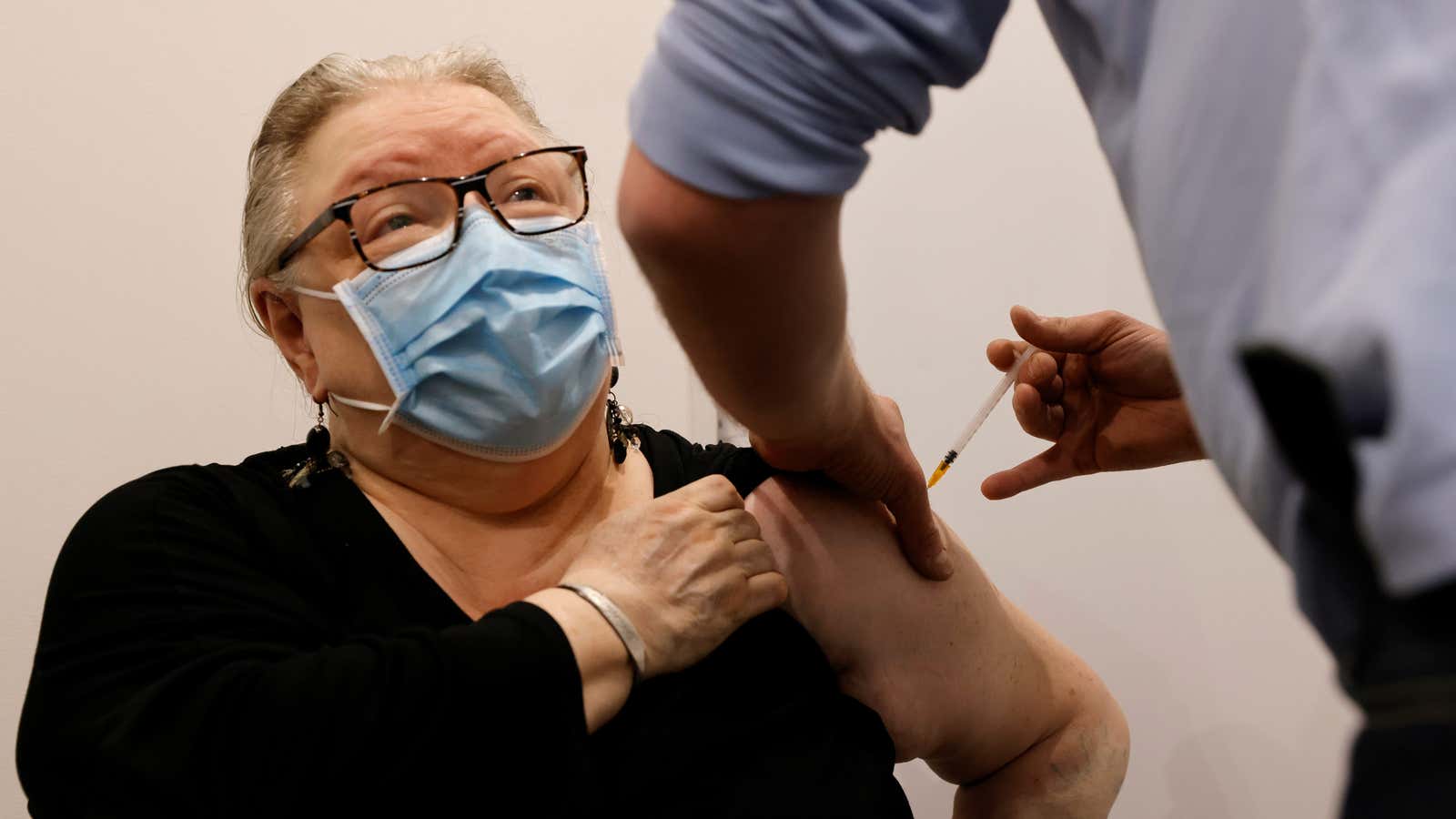 A pharmacist administers the AstraZeneca vaccine to a patient in France.