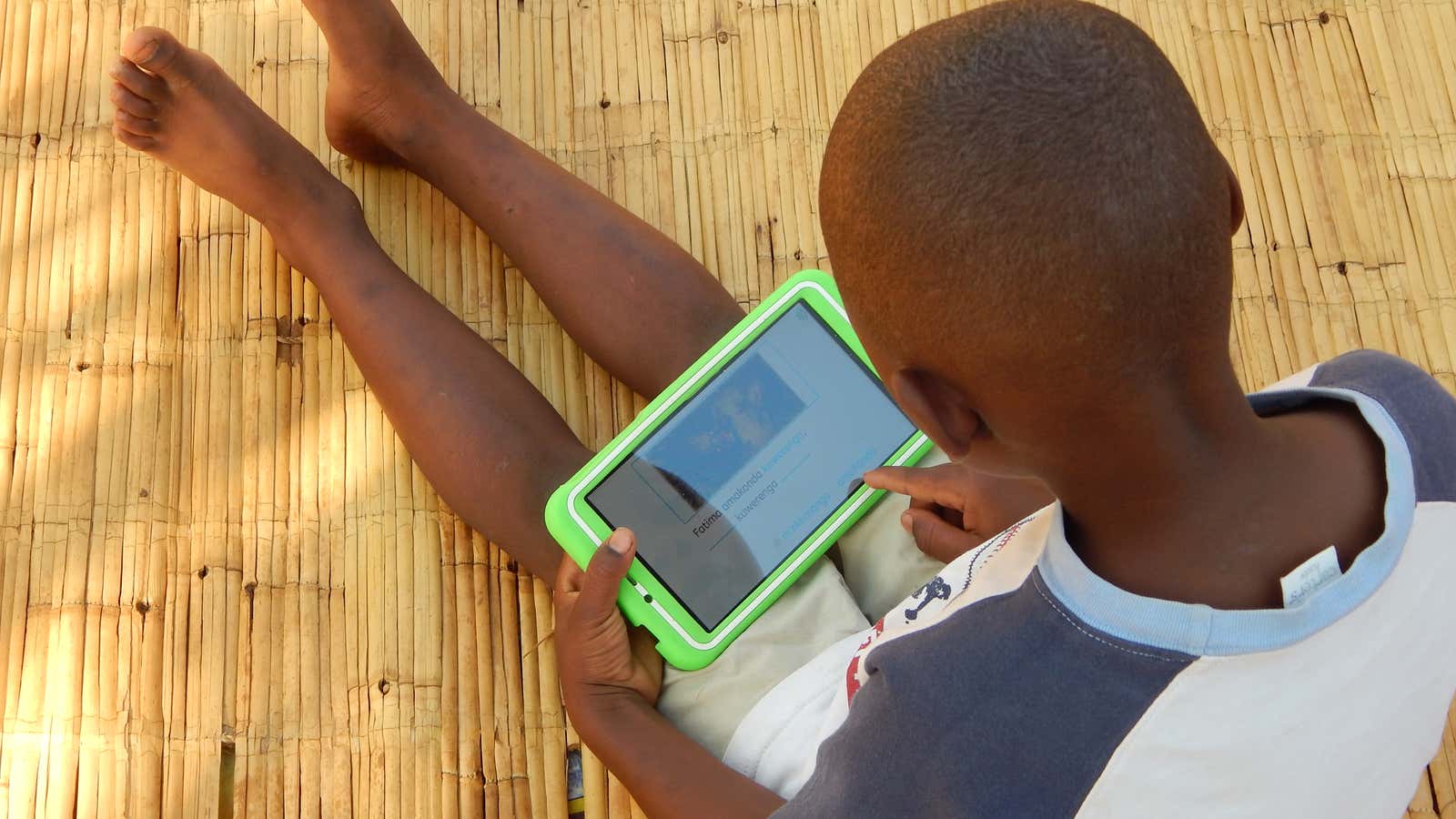 Eight-year-old Elijah Chiseka uses a learning tablet provided by the charity Voluntary Service Overseas in Gumulira village in western Malawi, September 23, 2020. Credit VSO/Charity Kanyoza