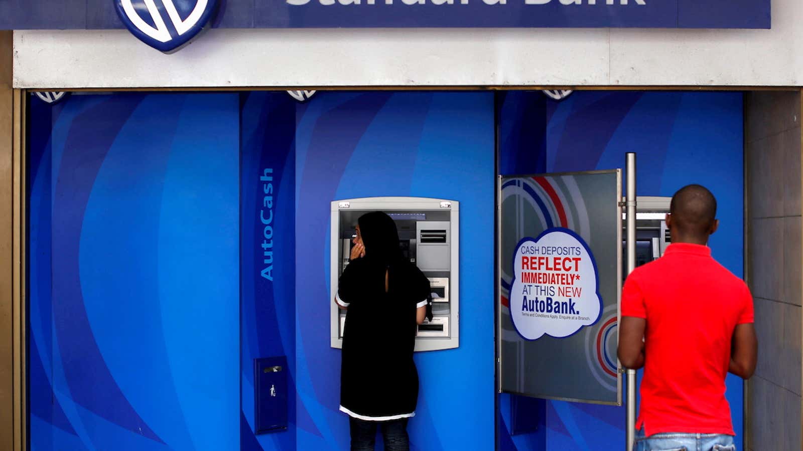 FILE PHOTO: Customers at an ATM at a branch of South Africa’s Standard Bank in Cape Town, March 15, 2016. REUTERS/Mike Hutchings/File Photo