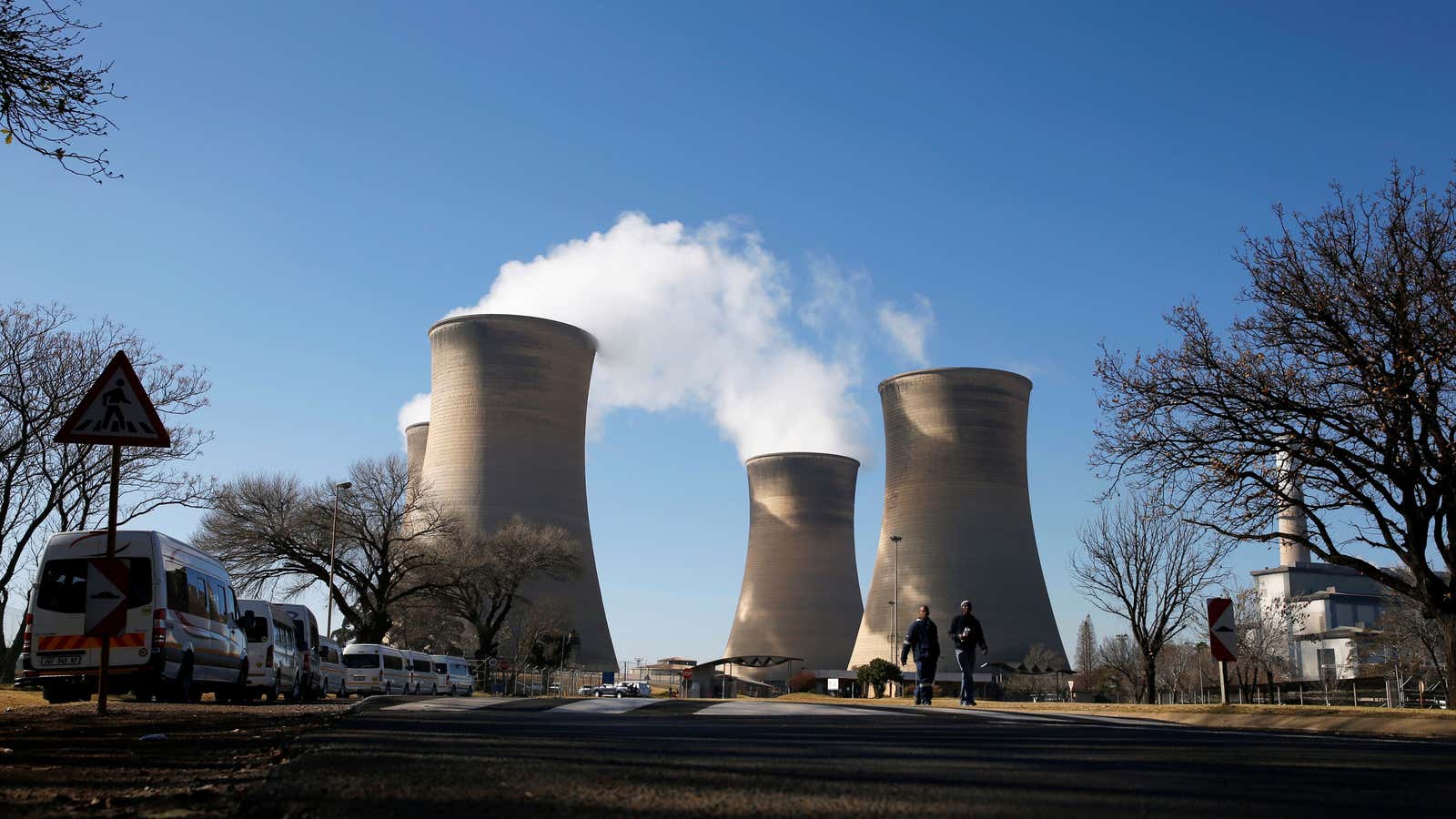 Workers are seen near cooling towers of the Hendrina power station, located south of Middelburg, South Africa