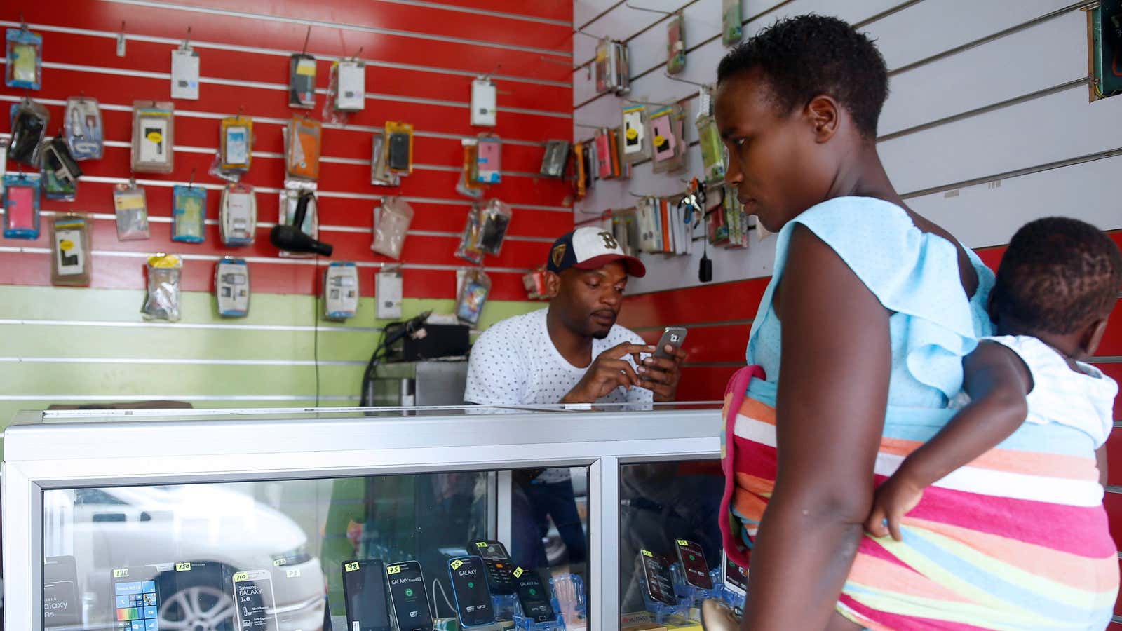 A visit to the bank? A woman looks at mobile phones at a shop in central Harare, Zimbabwe