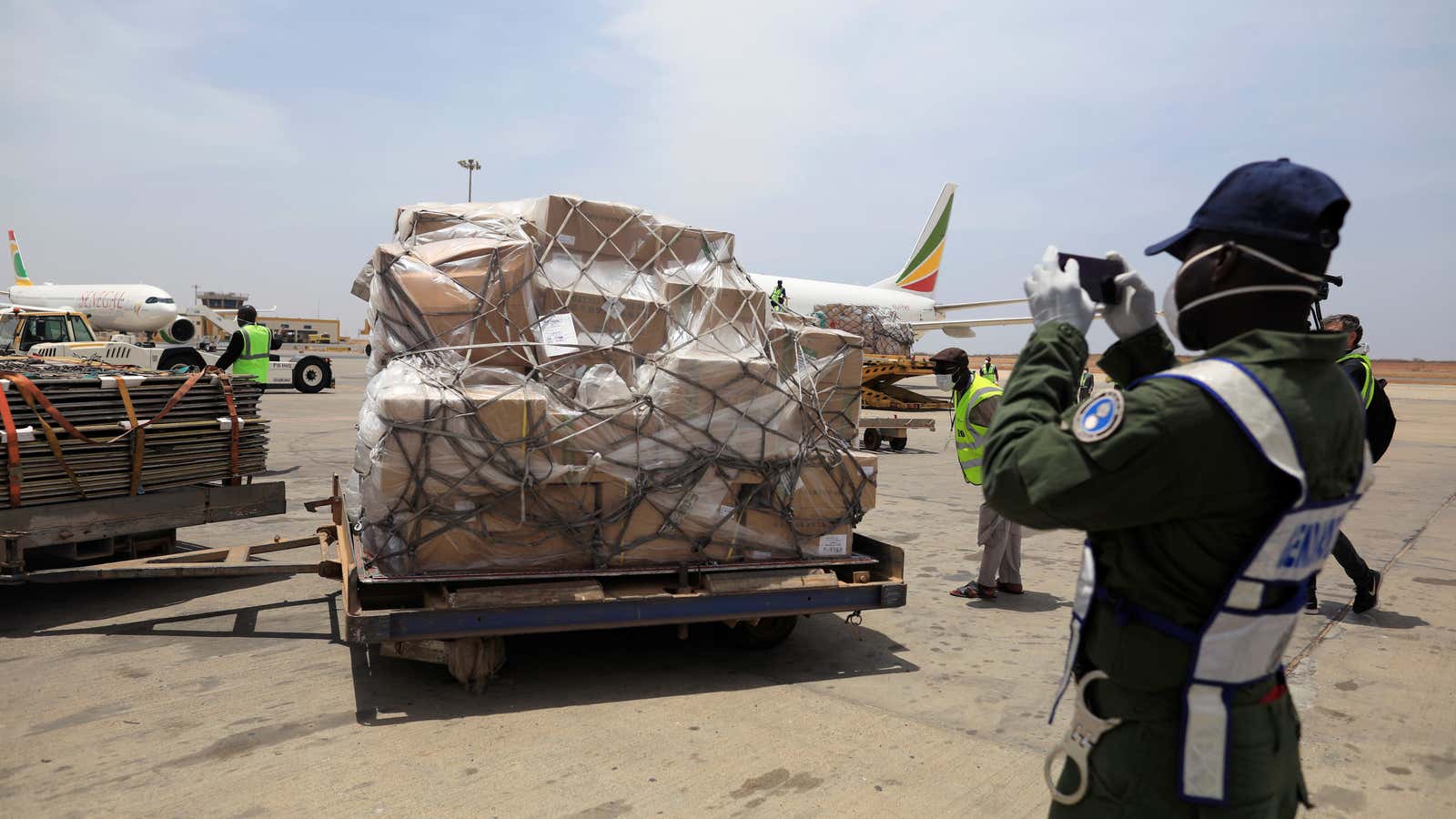 A gendarm takes photographs of a shipment of Covid-19 medical supplies donated  by Jack Ma and the Alibaba Foundation, after it arrived in Senegal from Ethiopia, March 2020.