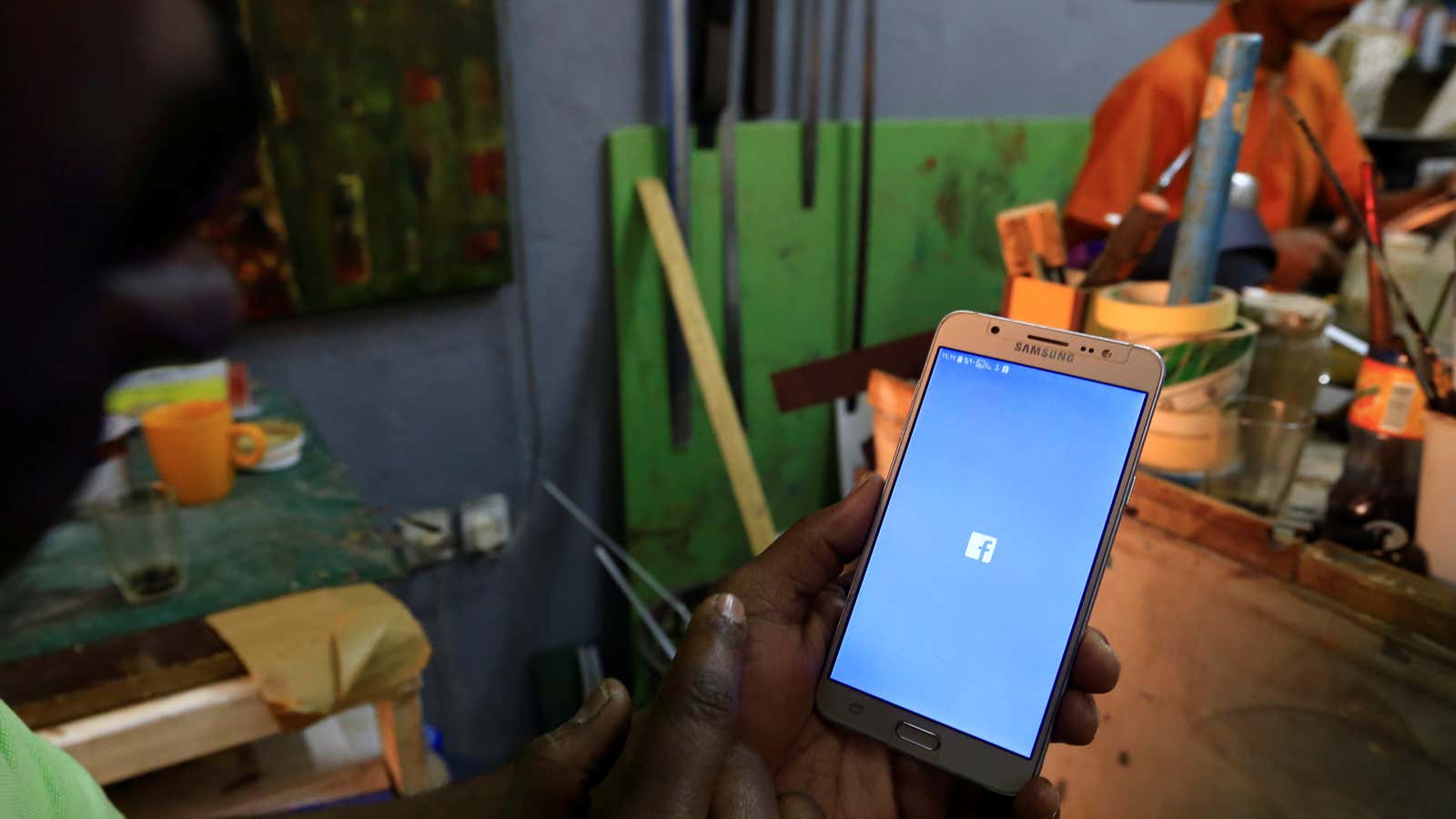 A Sudanese man holds his phone with restricted internet access social media platforms, in Khartoum, Sudan Jan. 1, 2019.