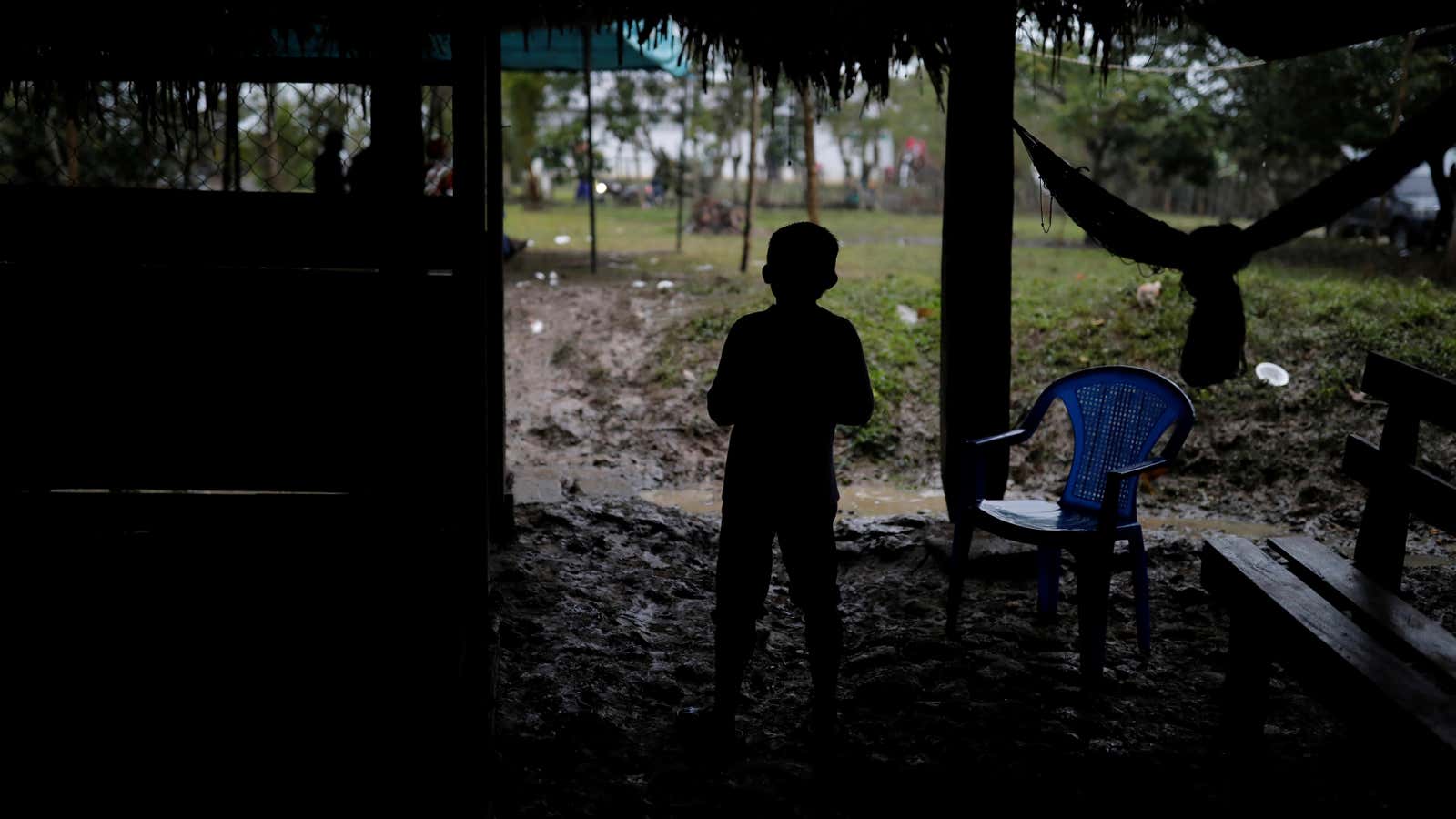 A boy stands by the coffin of Jakelin Caal, a 7-year-old girl who died in US custody.