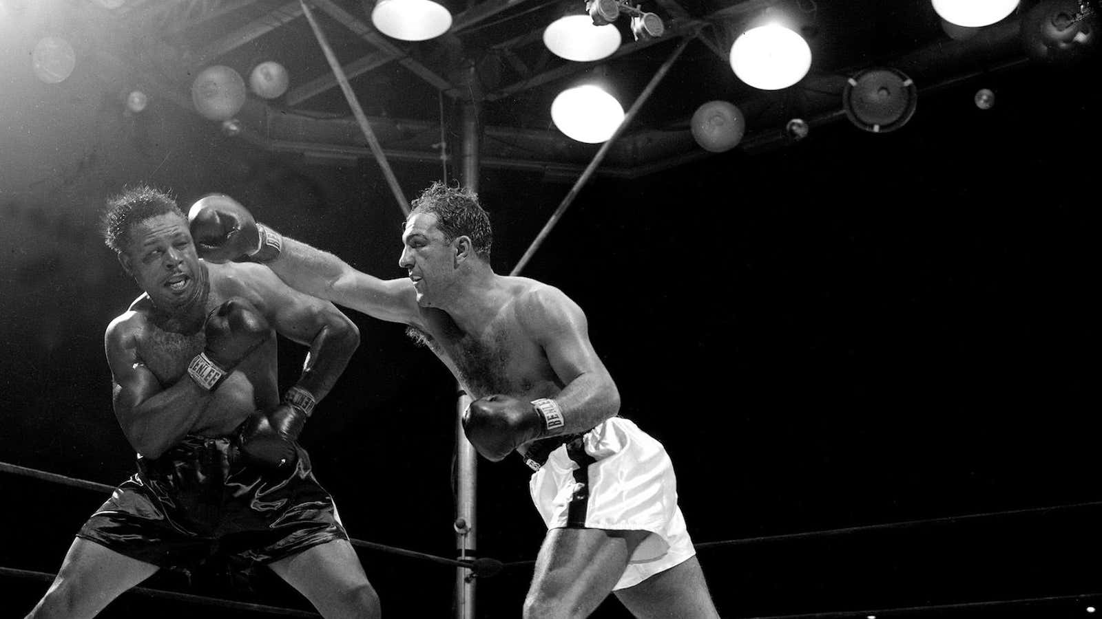 Rocky Marciano (right) hits Archie Moore at Yankee Stadium in 1955.