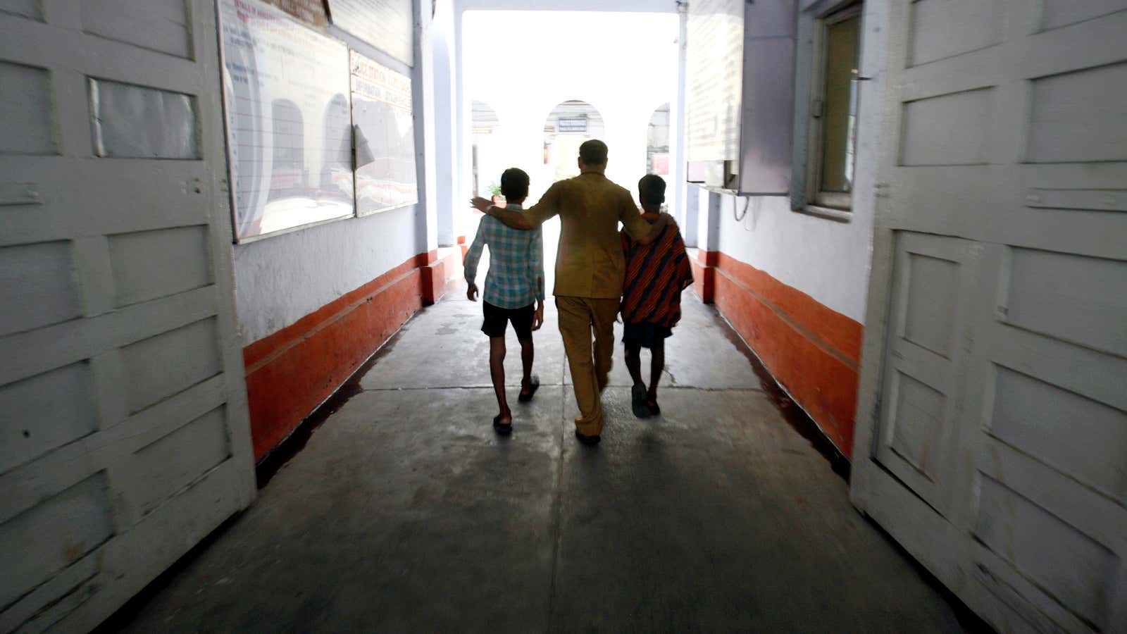 An NGO worker escorts child labourers rescued from a workshop.