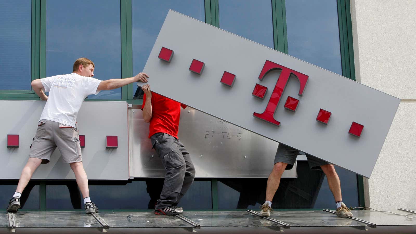 Workers redecorate a former Era Mobile phone outlet with T-Mobile logo in Warsaw June, 1, 2011. REUTERS/Kacper Pempel/File Photo GLOBAL BUSINESS WEEK AHEAD PACKAGE –…