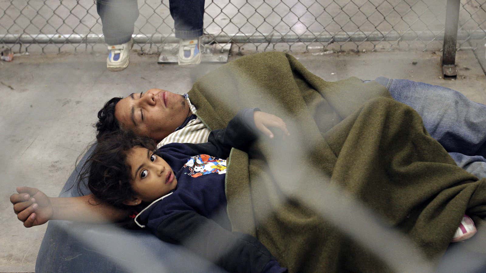 At an US border patrol detention center in Arizona, a Mexican immigrant and his child.