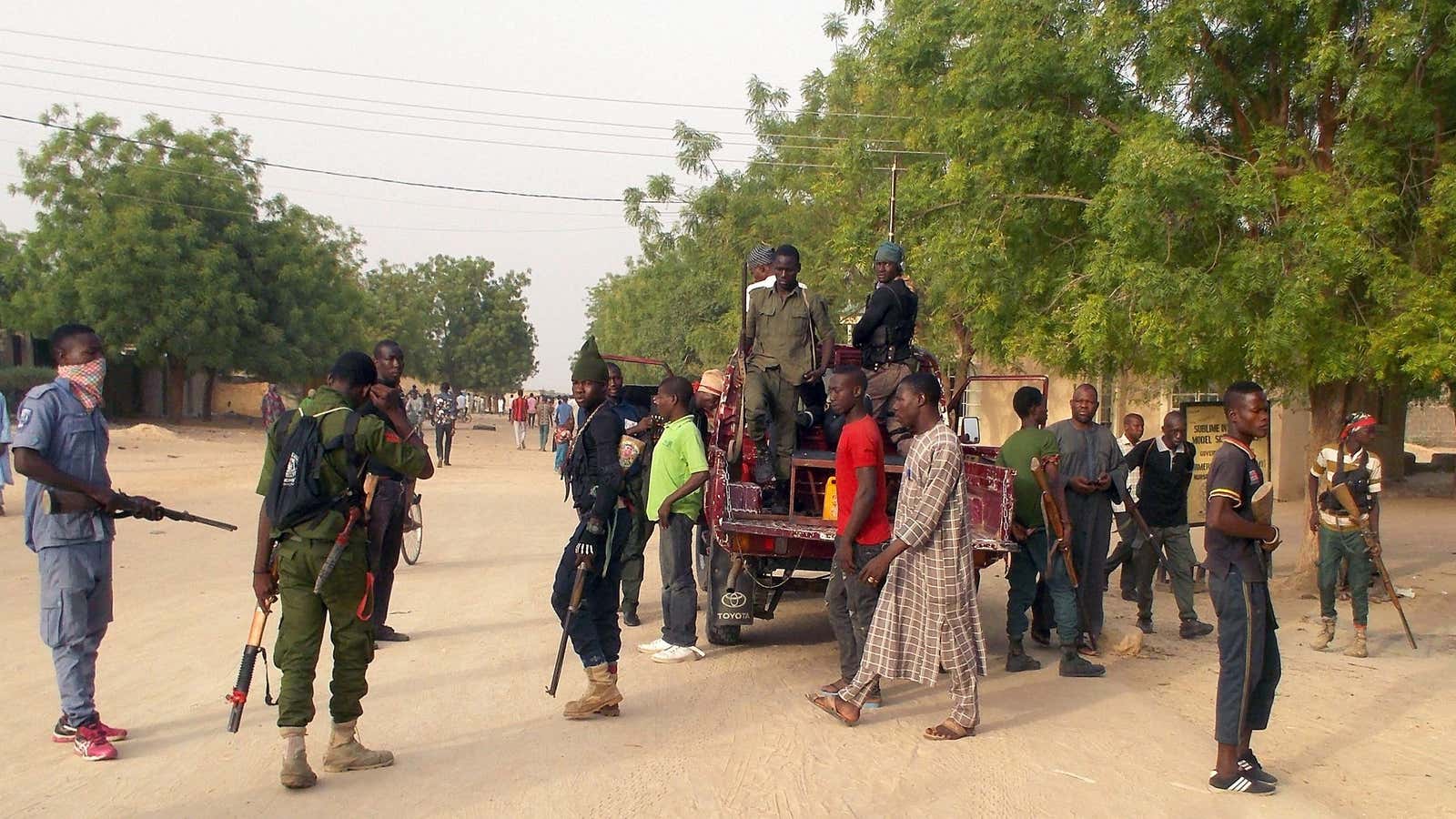 Local volunteers carrying weapons stand in the Jiddari Polo area in the northeastern city of Maiduguri, after an attack by Boko Haram militants, in Nigeria April 27, 2018.