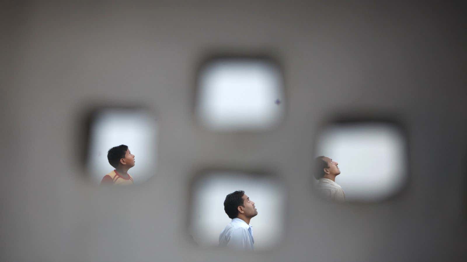 People look skywards as they fly kites from the roofs of their houses during India’s Independence Day celebrations in the old quarters of Delhi August…