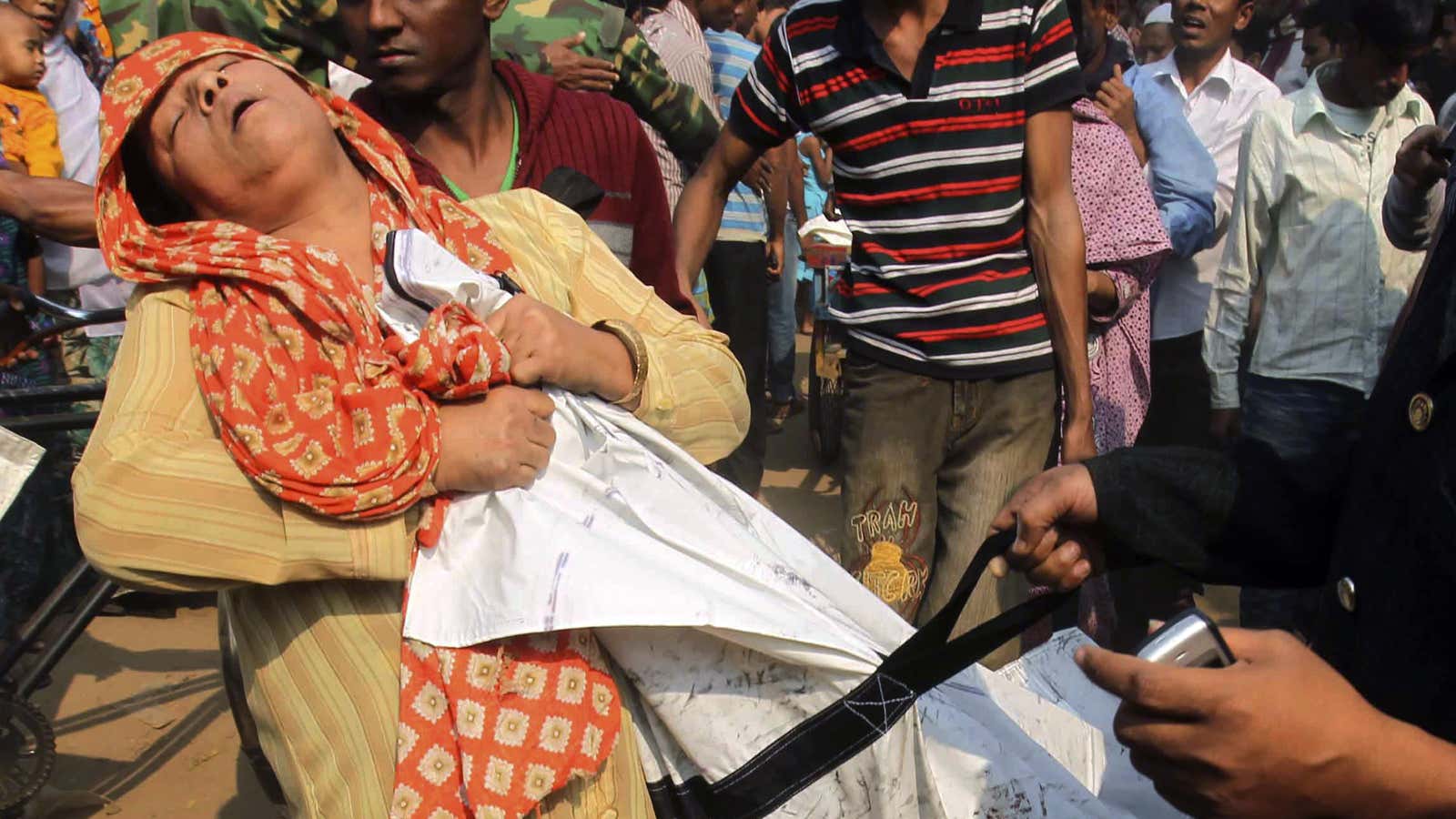 A woman clings to the body of a relative killed in the fire.