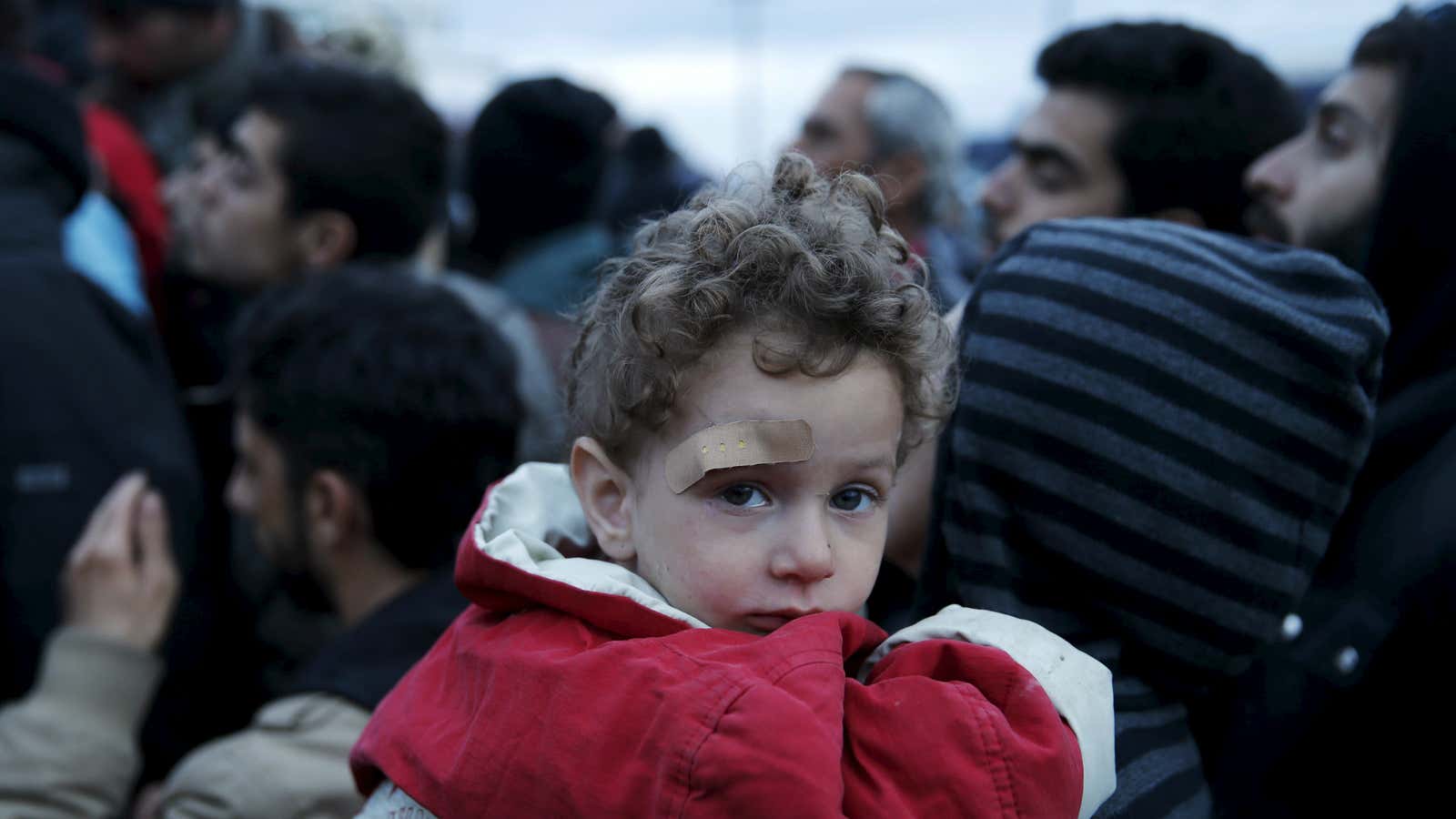 Migrants who are waiting to cross the Greek-Macedonian border, gather to receive travel documents near the village of Idomeni, Greece, March 3, 2016. REUTERS/Marko Djurica