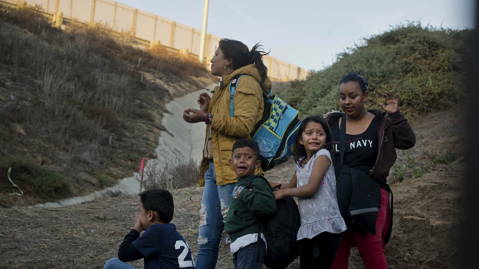 Honduran migrants react as they surrender to Border Patrol after crossing the US border.