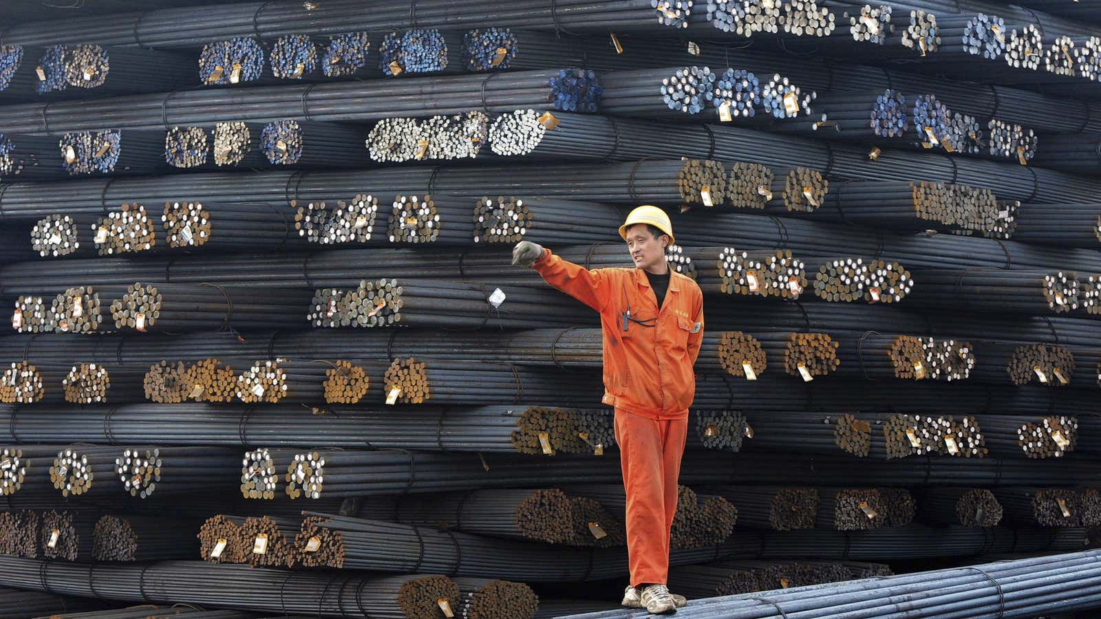 A dock worker stands on steel rods in Qingdao.