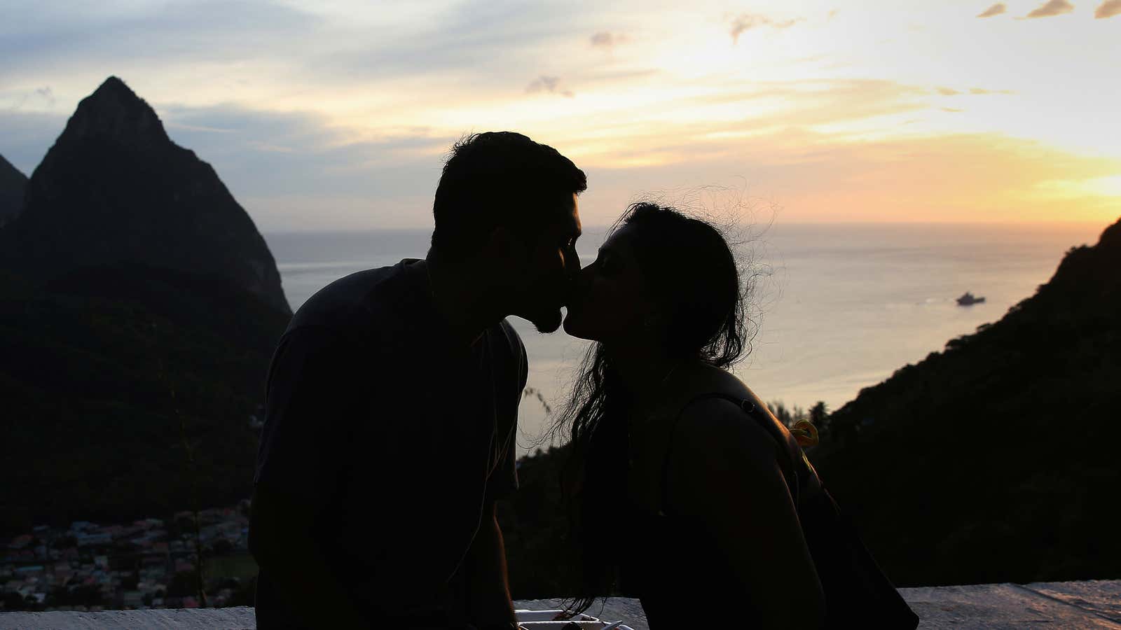 People seen during sunset with the volcanic Pitons in the background in Soufriere, St. Lucia, November 25, 2016.  REUTERS/Carlo Allegri – RTSTBZX