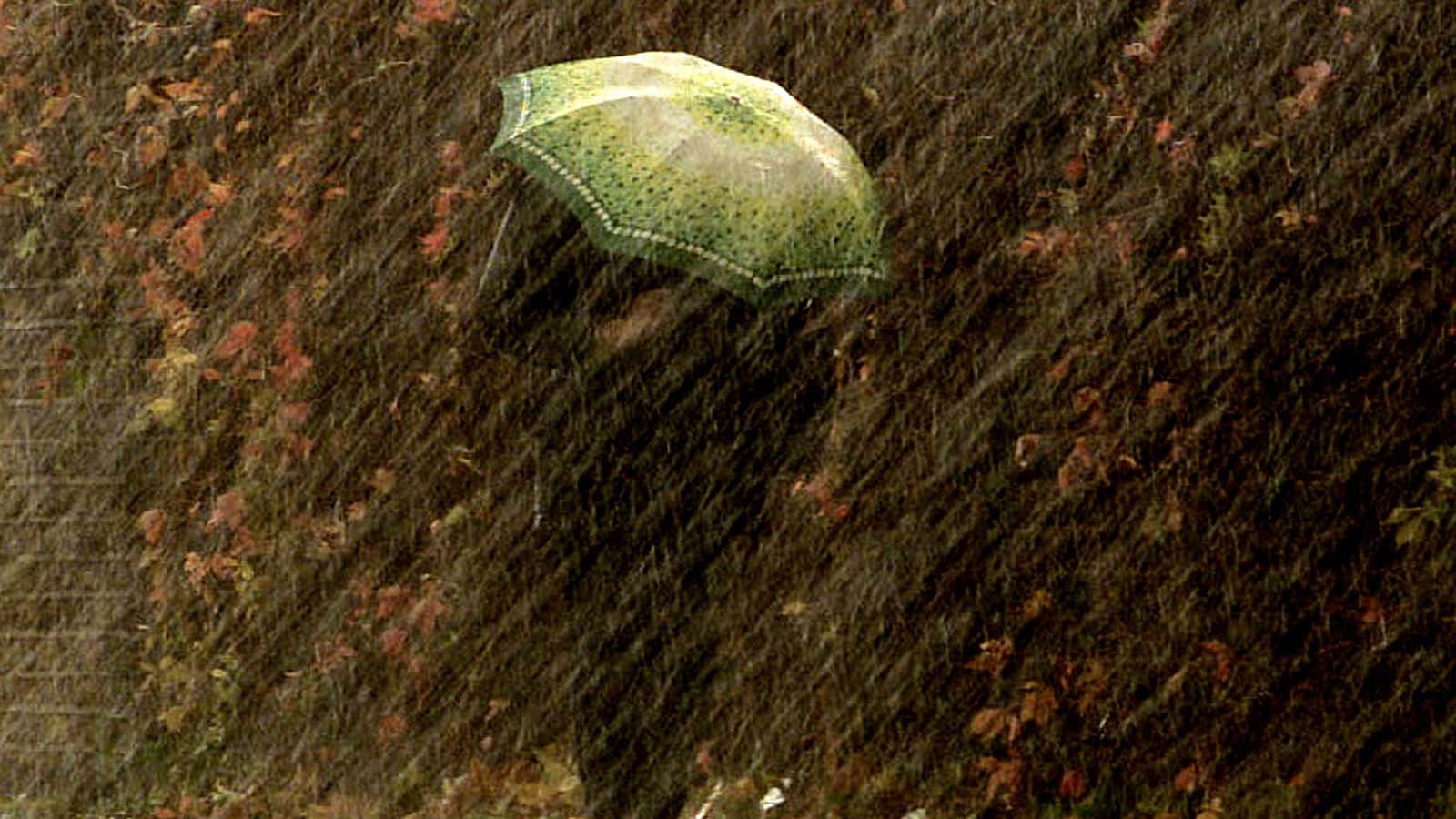 A woman struggles under her umbrella on her way to work in gale force winds and rain in East London October 30, 2000. The worst…