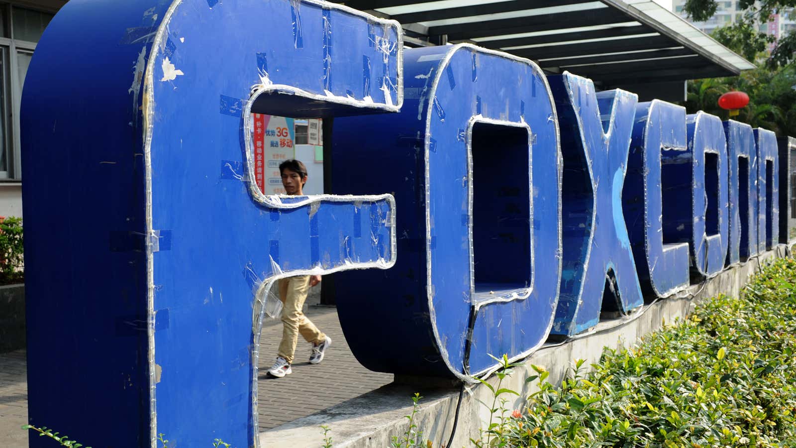 A young man walking past a Foxconn recruitment point in Shenzhen, south China&#39;s Guangdong province.