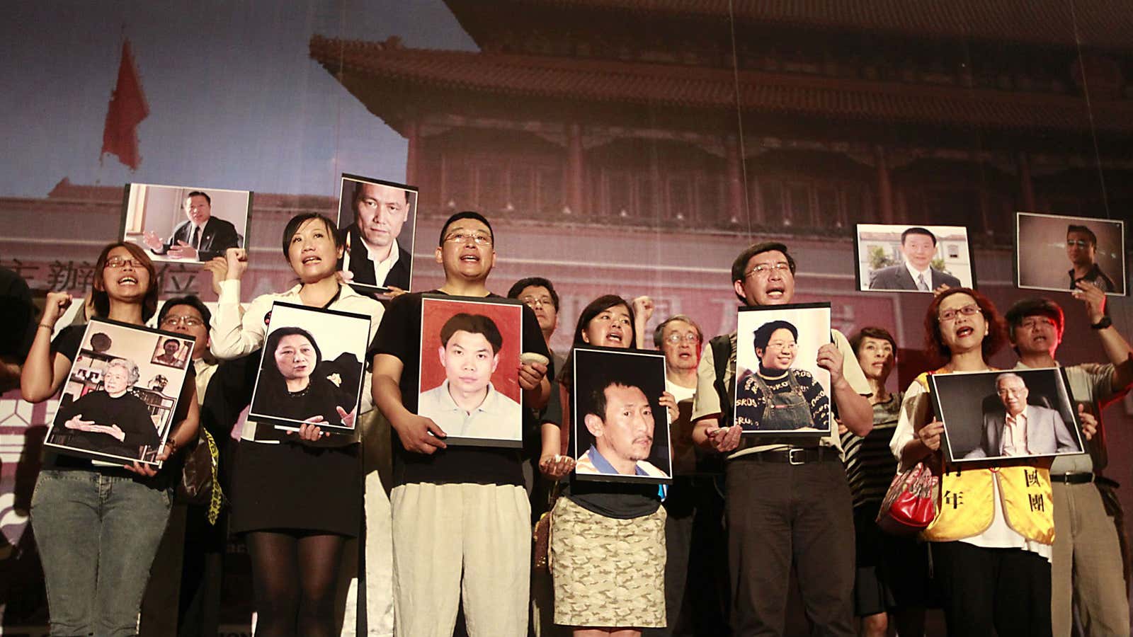 Protestors hold up photos of Chinese political prisoners.