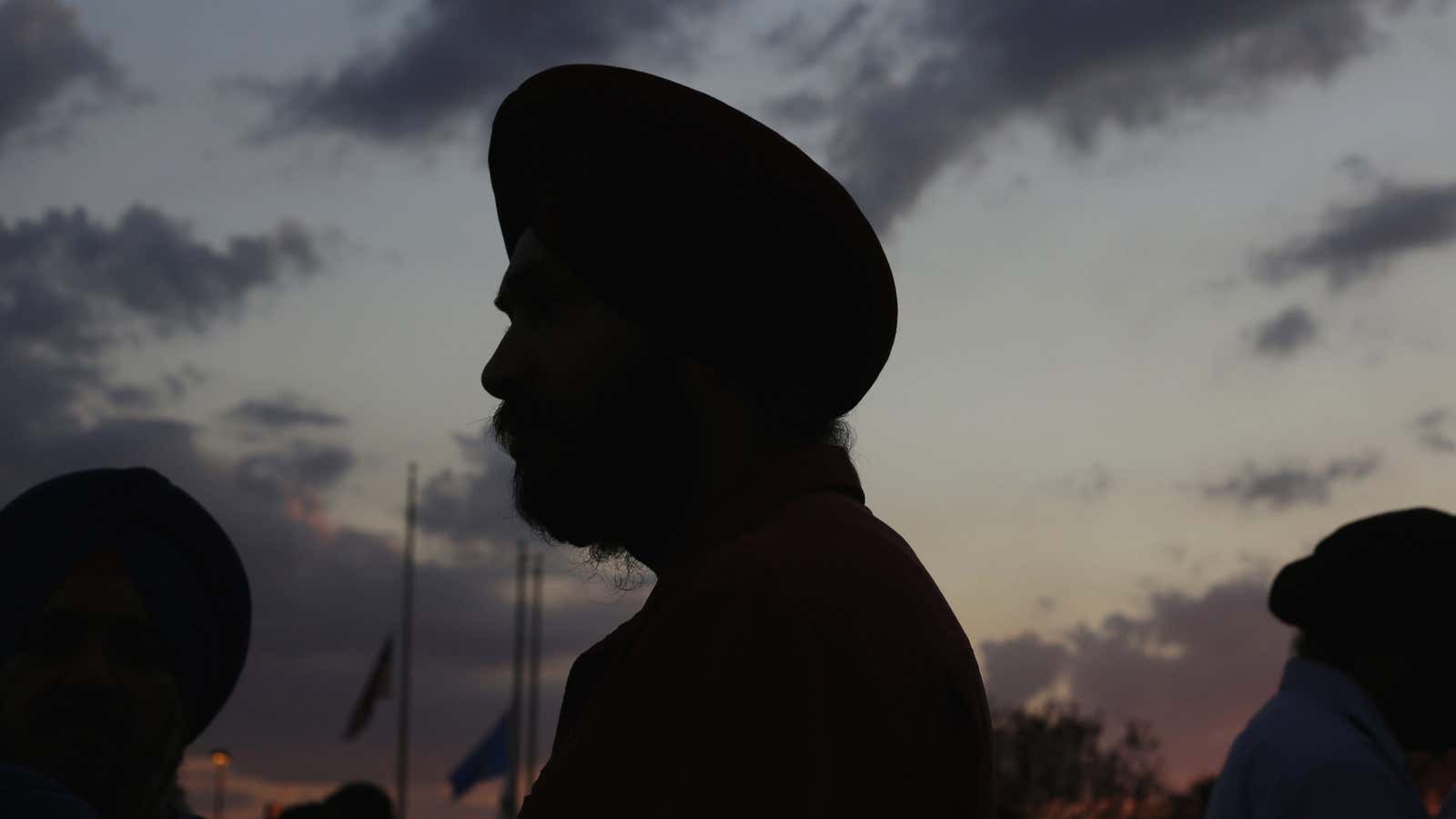 Flags fly at half staff as Sikhs prepare for a vigil in Oak Creek, Wisconsin, August 7, 2012. The killings of six worshippers at a Sikh temple in Wisconsin has thrust attention on white power music, a thrashing, punk-metal genre that sees the white race under siege. REUTERS/John Gress (UNITED STATES – Tags: CRIME LAW RELIGION TPX IMAGES OF THE DAY) – GM2E8880T9O01