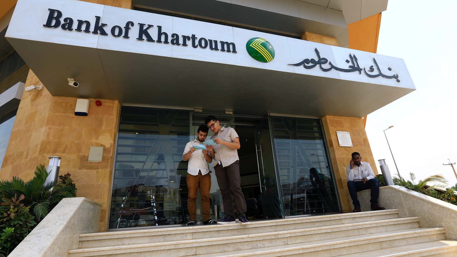 Customers wait outside the Bank of Khartoum, Sudan