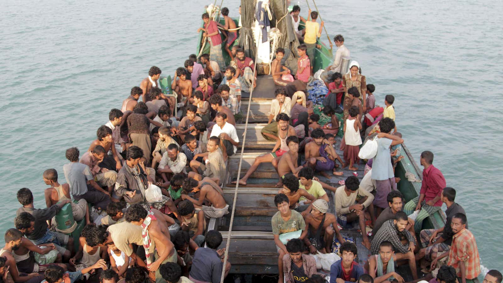 Rohingya and Bangleshi migrants wait on board a fishing boat before being transported to Indonesia’s Aceh province.