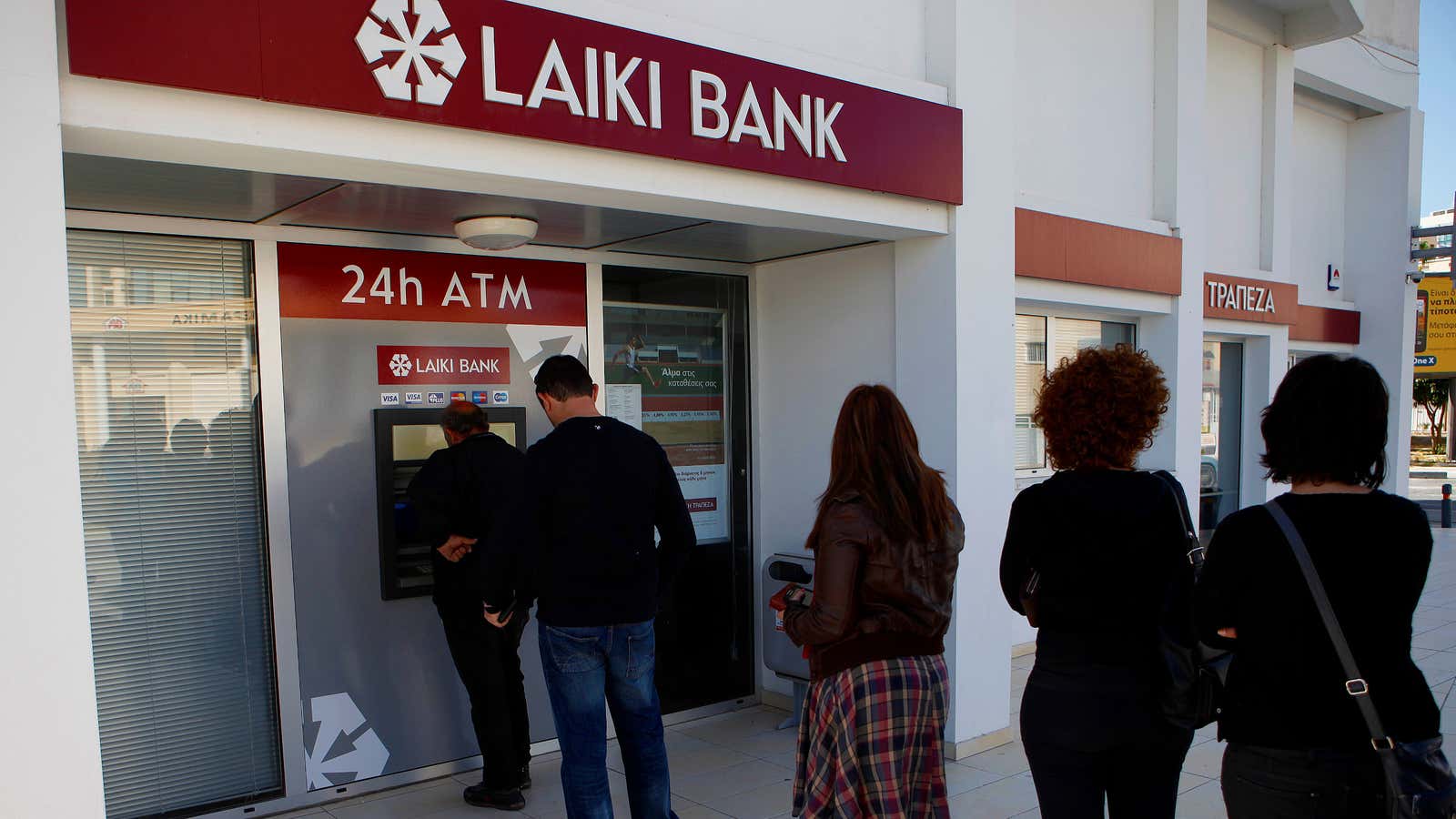 People wait to withdraw money from an ATM in Cyprus after news broke of an impending deposit tax.