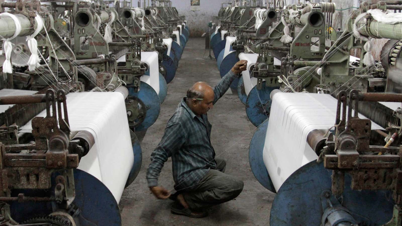 A man works in a textile factory in Ahmadabad, India. An economist asks: Is he being managed well enough to succeed?