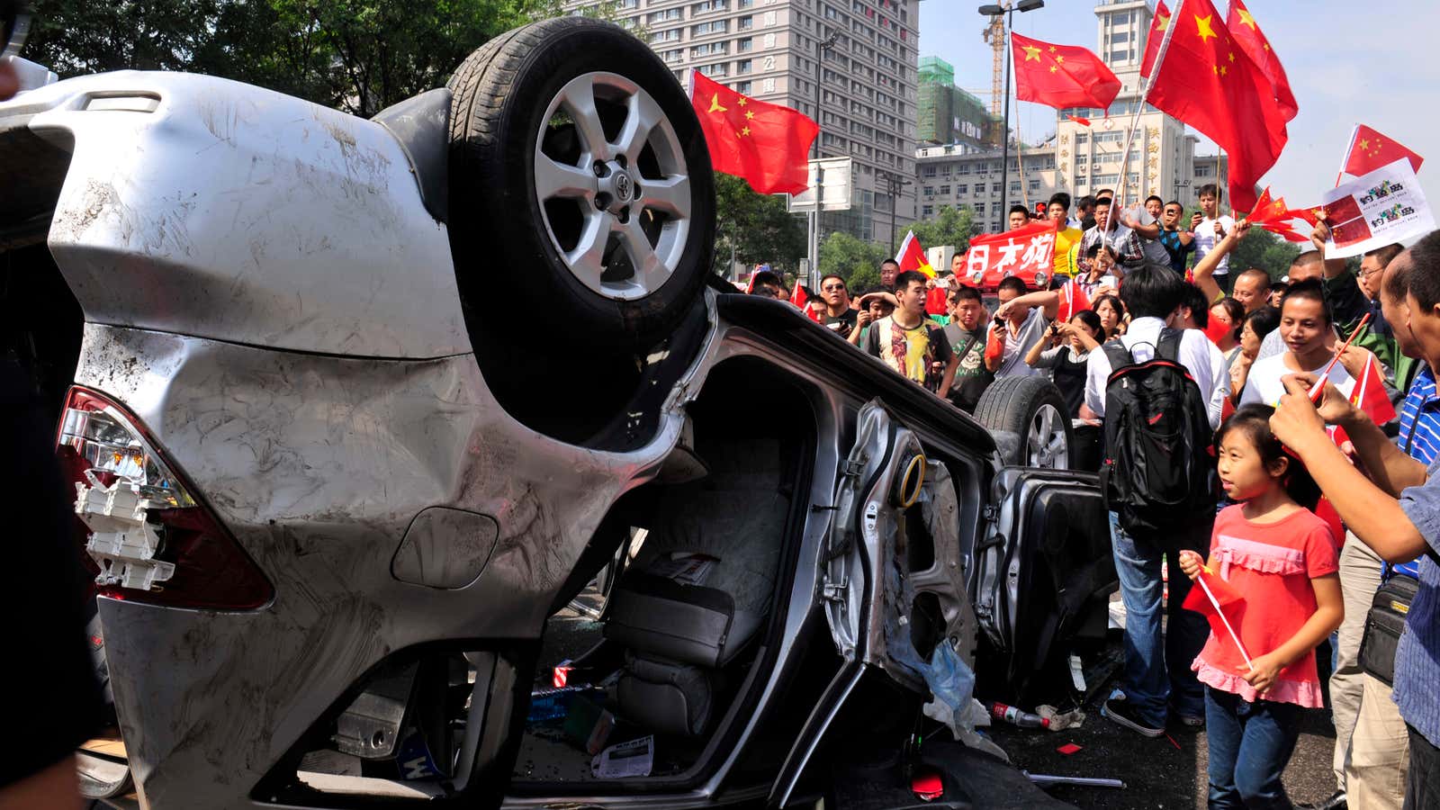 Chinese demonstrators in  Shaanxi province trash a Japanese car after a political dispute in 2012.