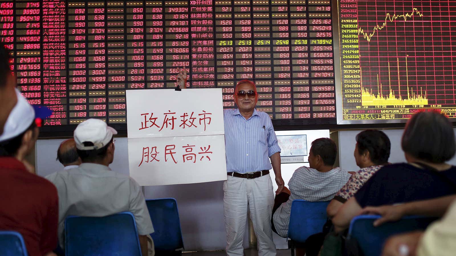 “The government saves the market, investors are happy,” reads the sign.