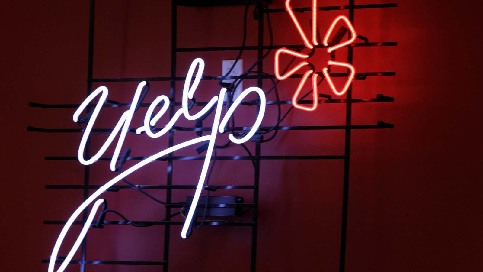 FILE – In this Oct. 26, 2011 file photo, the logo of the online reviews website Yelp is shown in neon on a wall at…