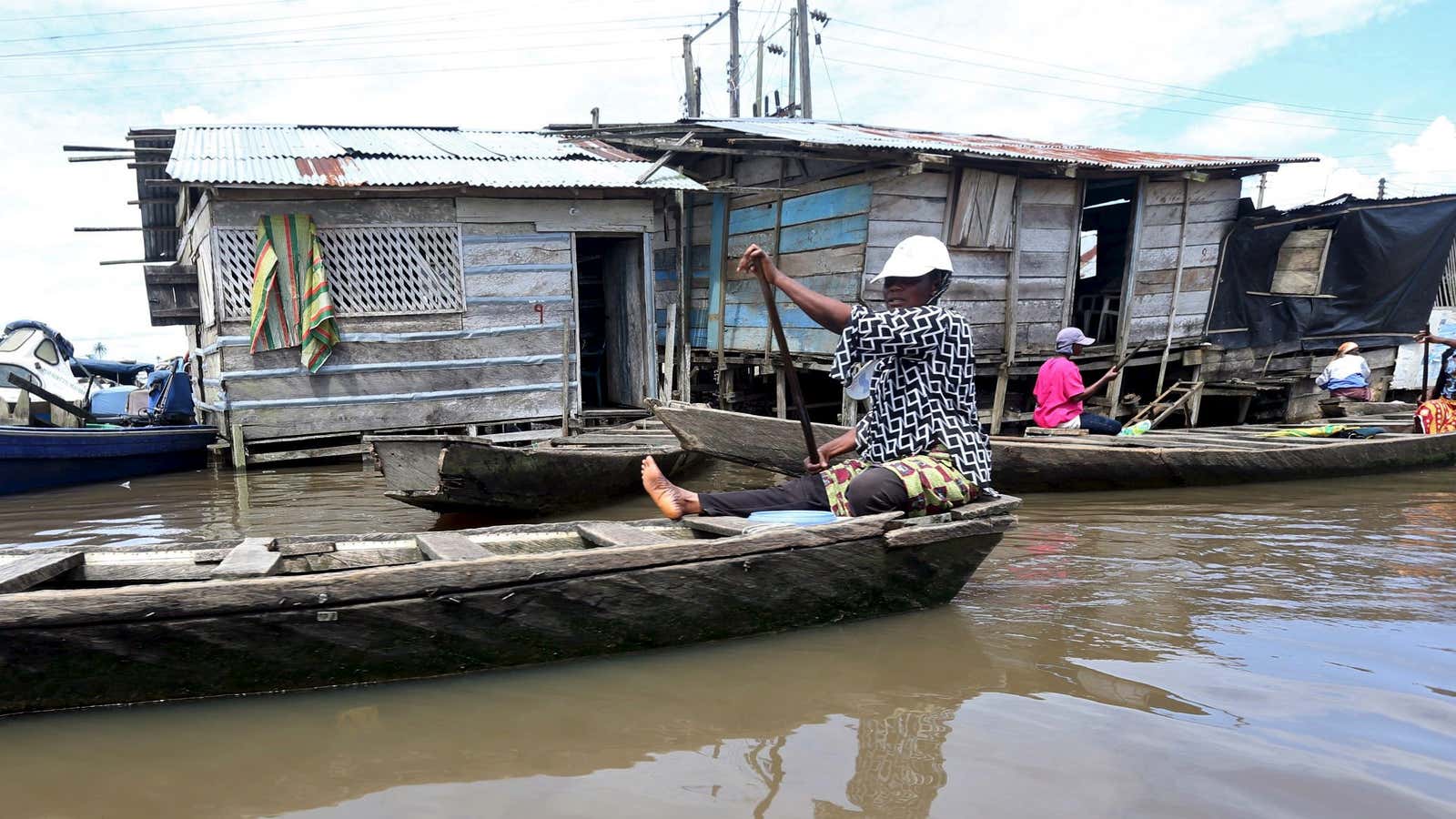 A woman paddles a canoe at Swali jetty on the Nun River in Nigeria’s delta region