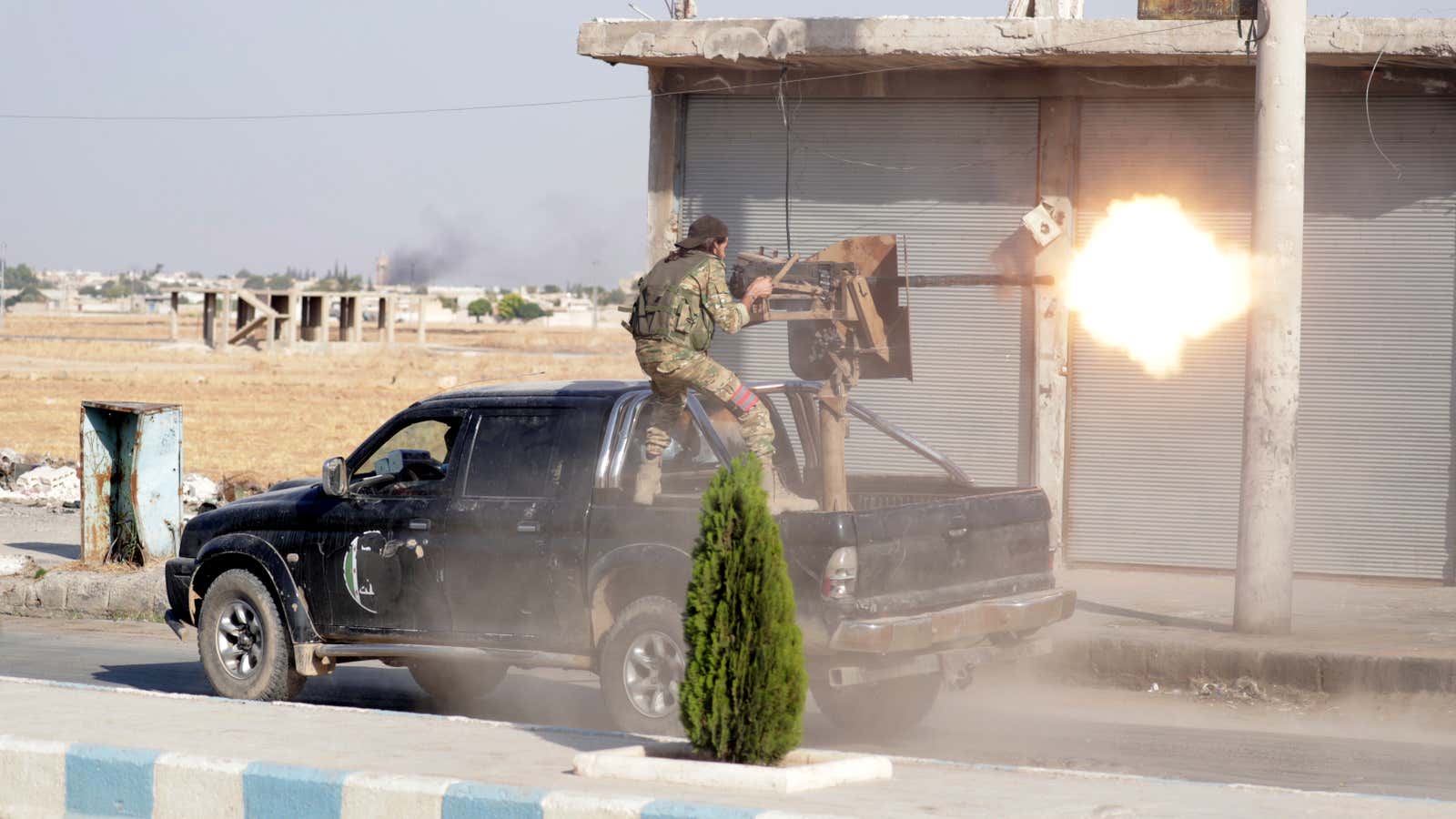 A Syrian fighter backed by Turkey firing a weapon on Oct. 13.