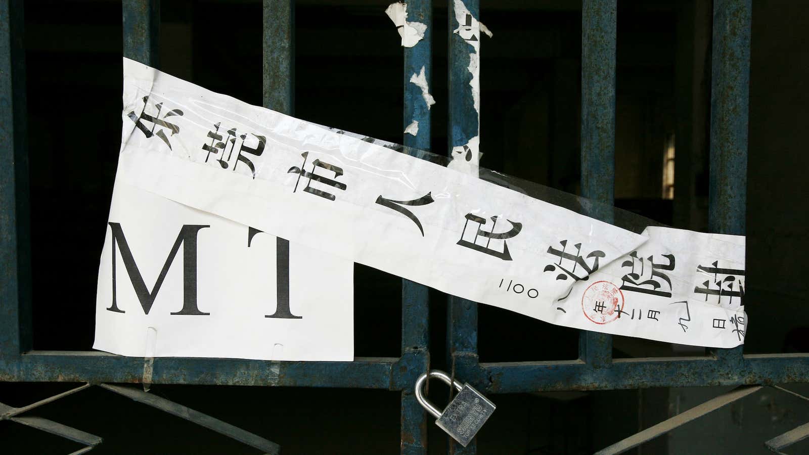 A sign reading “Dongguan City People’s Court” is taped over a shuttered factory, one of many in the once-thriving export hub.