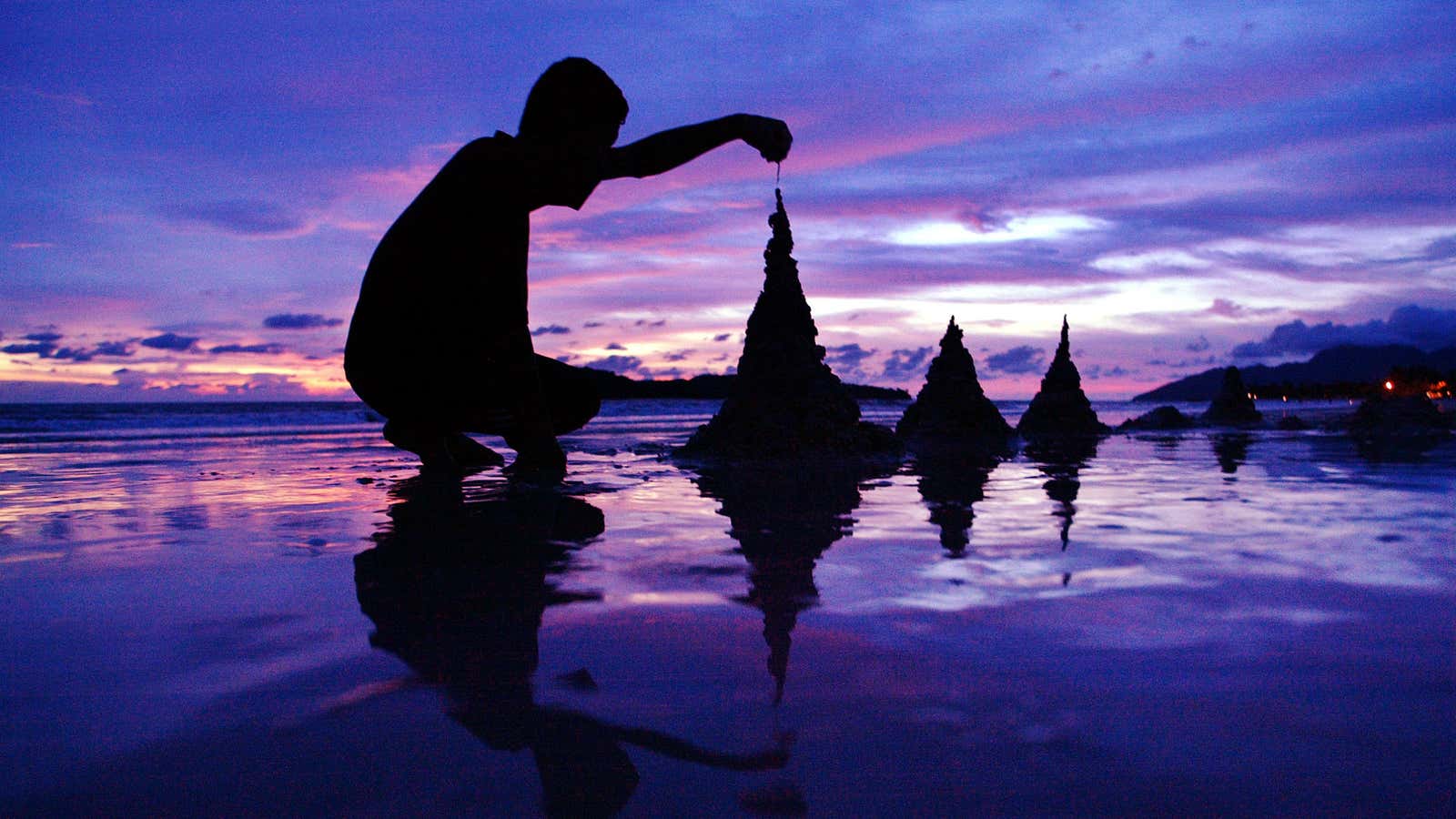 A tourist build sandcastles on Chenang Beach on the  island of Langkawi.