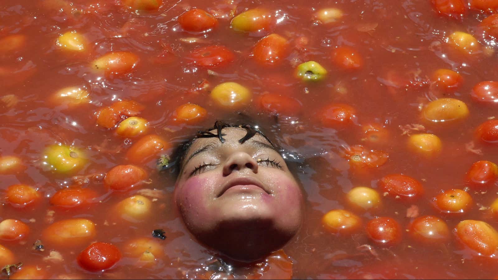 A child rests inside tomato pulp as part of Holi, also known as the festival of colours, in the southern Indian city of Hyderabad February…