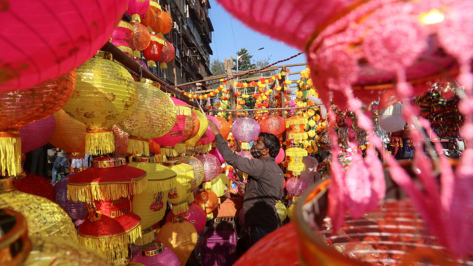 A vendor hangs a lantern at a market on the eve of Diwali, amidst the spread of COVID-19 in Mumbai, India, November 13, 2020.