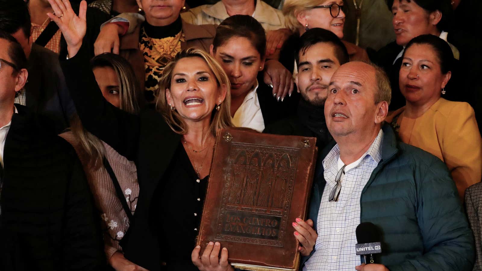 Bolivian Senator Jeanine Anez brandishes a massive bible outside Bolivia’s presidential palace, having declared herself president.