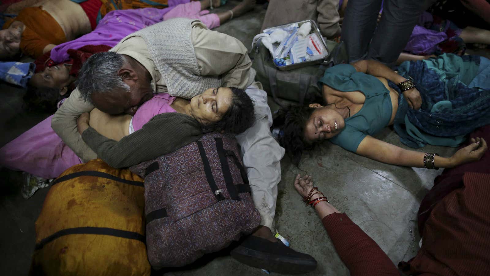 A man weeps as he holds his wife, among the dozens dead in a stampede in Allahabad, India, the site of a religious festival.