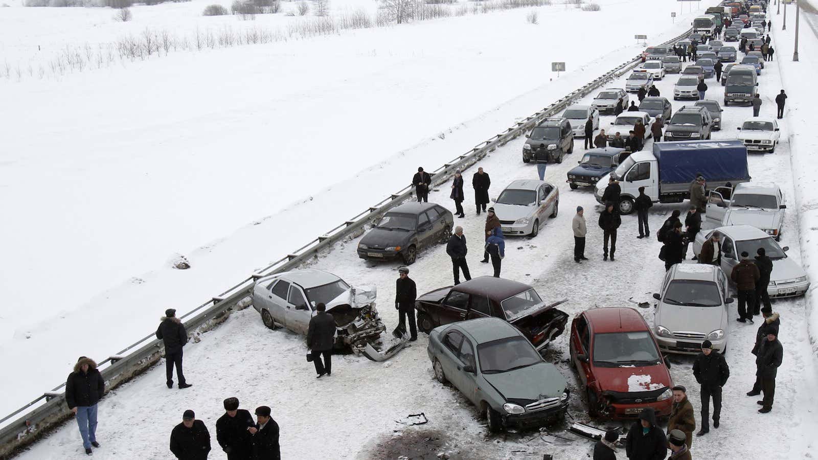 People stand at the site of a car accident which caused a traffic jam on a road from the airport to the city of Kazan,…