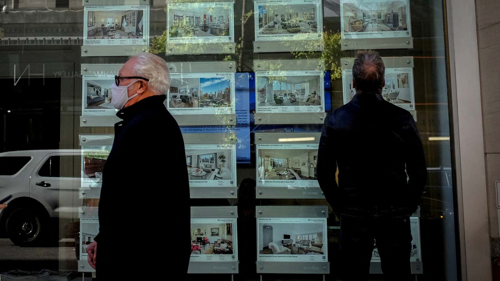 A man looks at advertisements for luxury apartments and homes in the window of a Douglas Elliman Real Estate sales business in Manhattan’s upper east side neighborhood in New York City, New York, U.S. October 19, 2021.