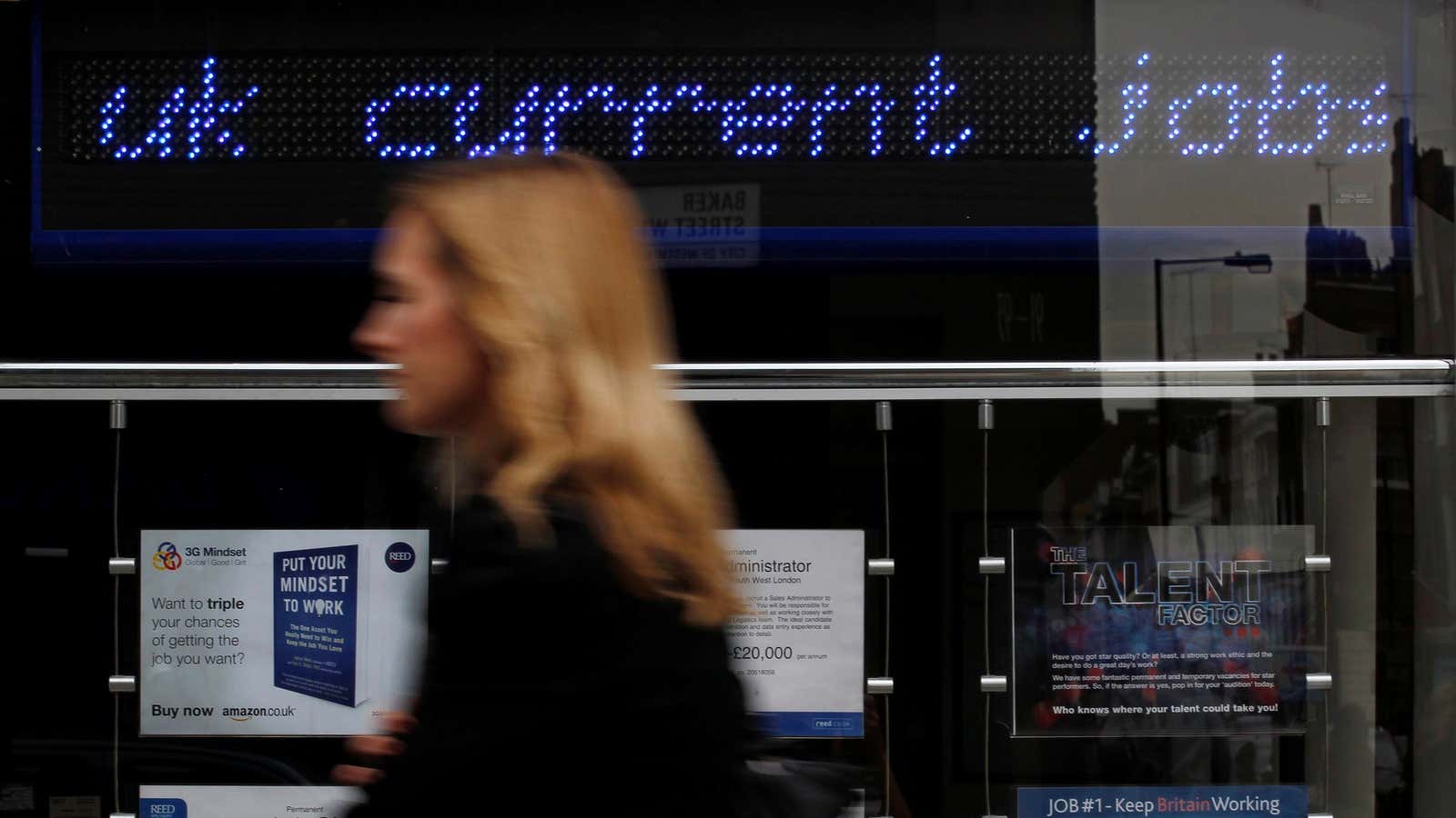 A pedestrian walks past an employment center in London.