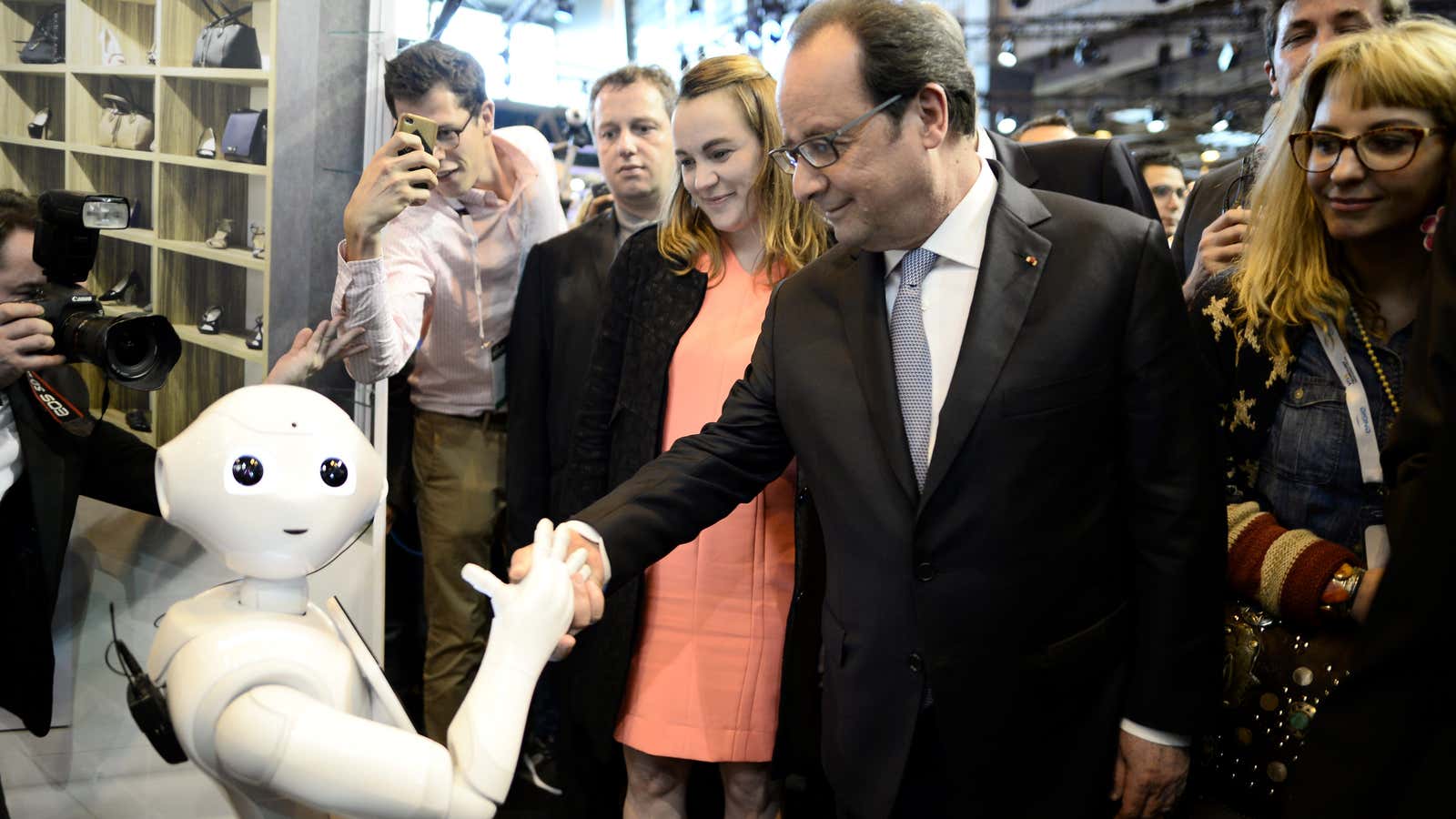 French President Francois Hollande shakes hands with an IBM Watson powered robot.