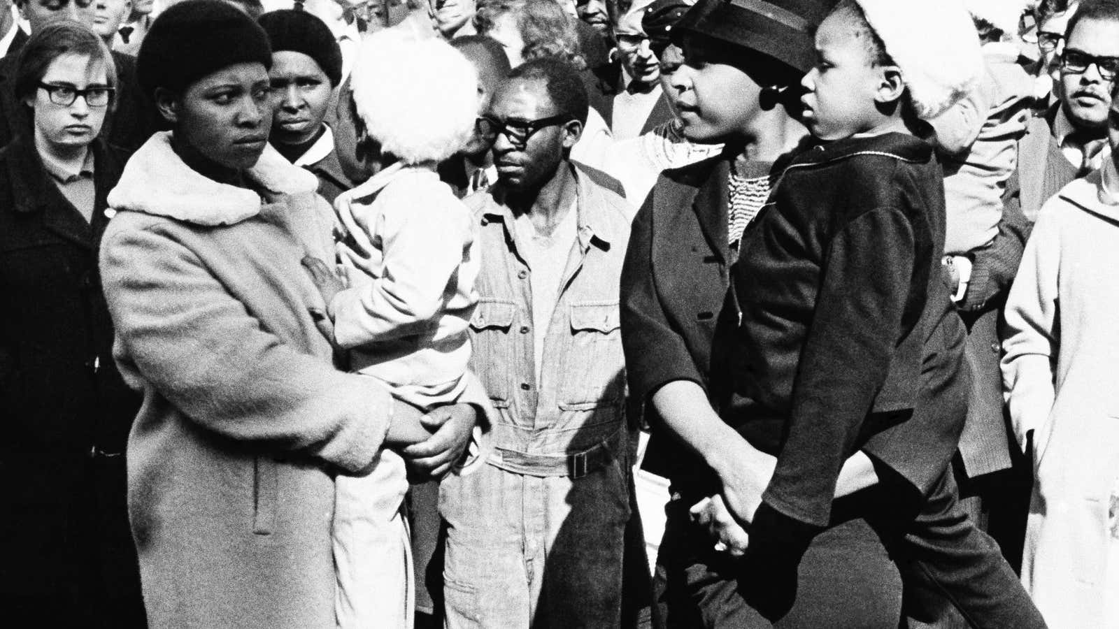 In this June 12, 1964, file photo, Winnie Mandela, right, waits in vain for a glimpse of her husband, Nelson Mandela in Pretoria, South Africa. She’s one of the few women acknowledged for her role.