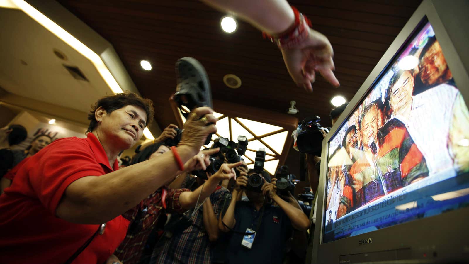 Not having it: a government supporter takes her shoe to a rival party’s candidate