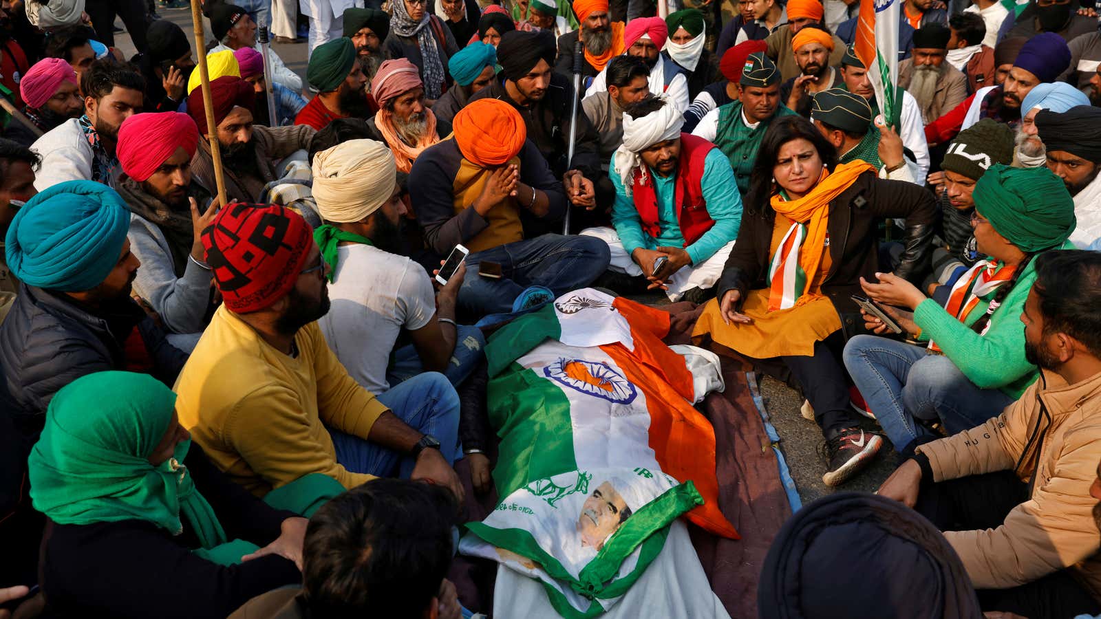 Farmers sit around the body of a person who died during the violence.