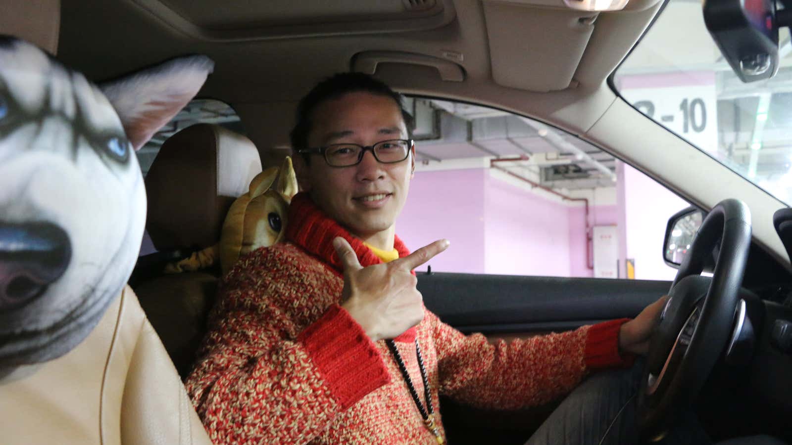 Uber driver Jasper Fu in his BMW (with dog head pillow).